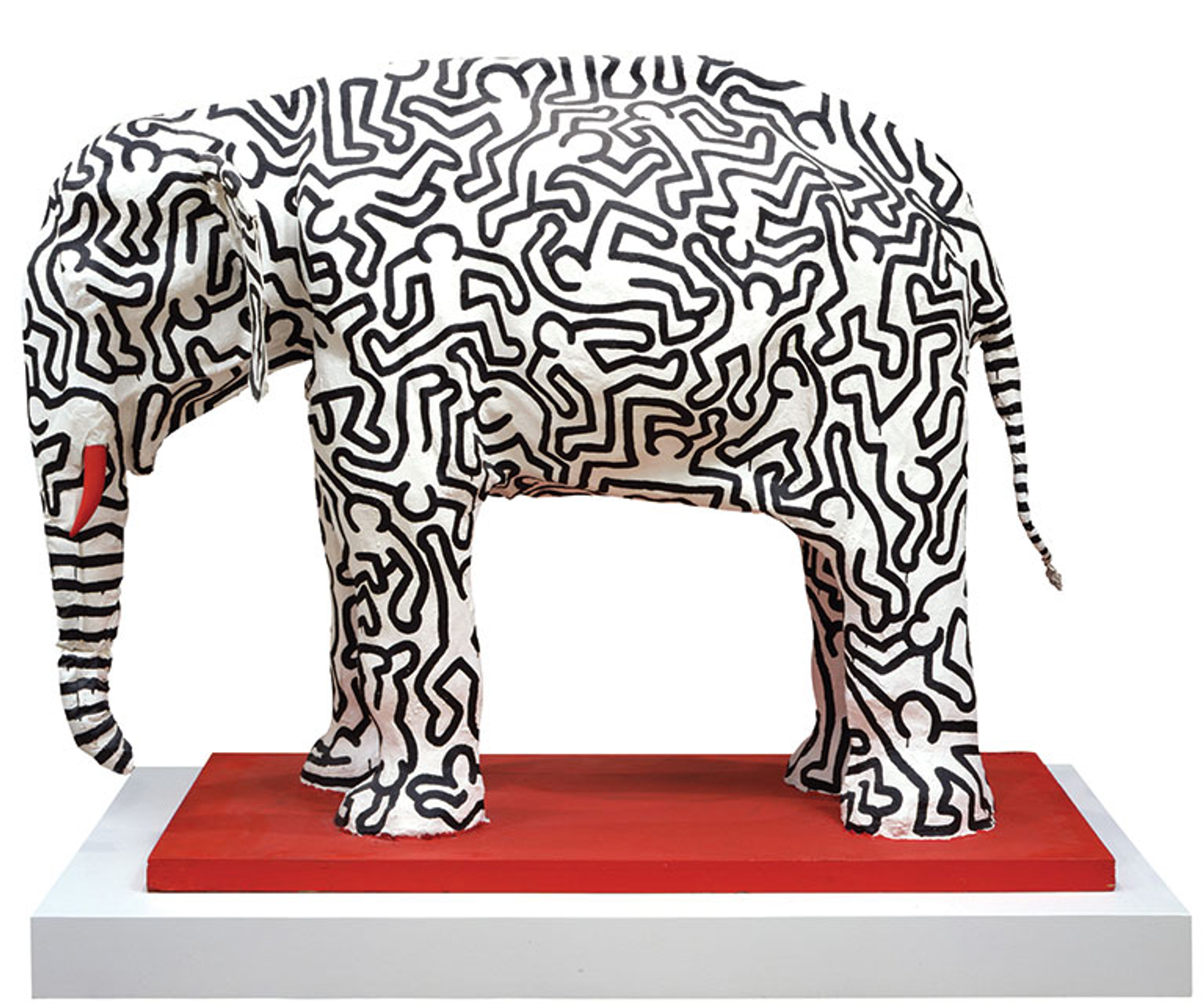 Keith Haring’s Untitled (Elephant). A paper mache sculpture of a white elephant with red tusks and black animated figures on its body.