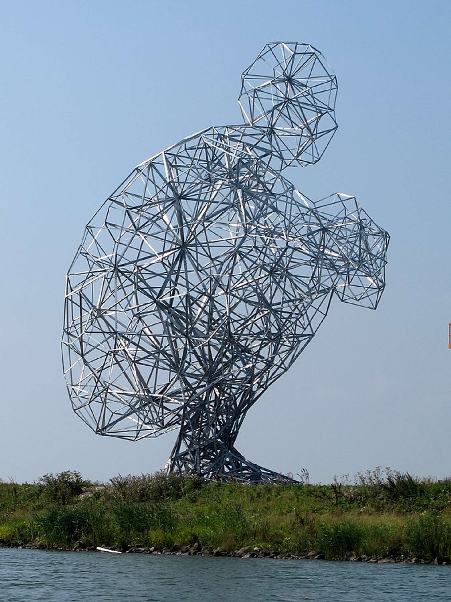 Anthony Gormley's 2010 sculpture, Exposure. A sculpture of a human figure, crouched and hugging its knees, constructed using stainless steel struts. 