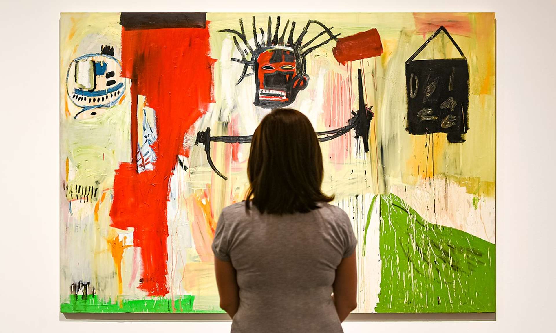 Jean-Michel Basquiat's Self-Portrait (1986), with a woman looking at the painting.