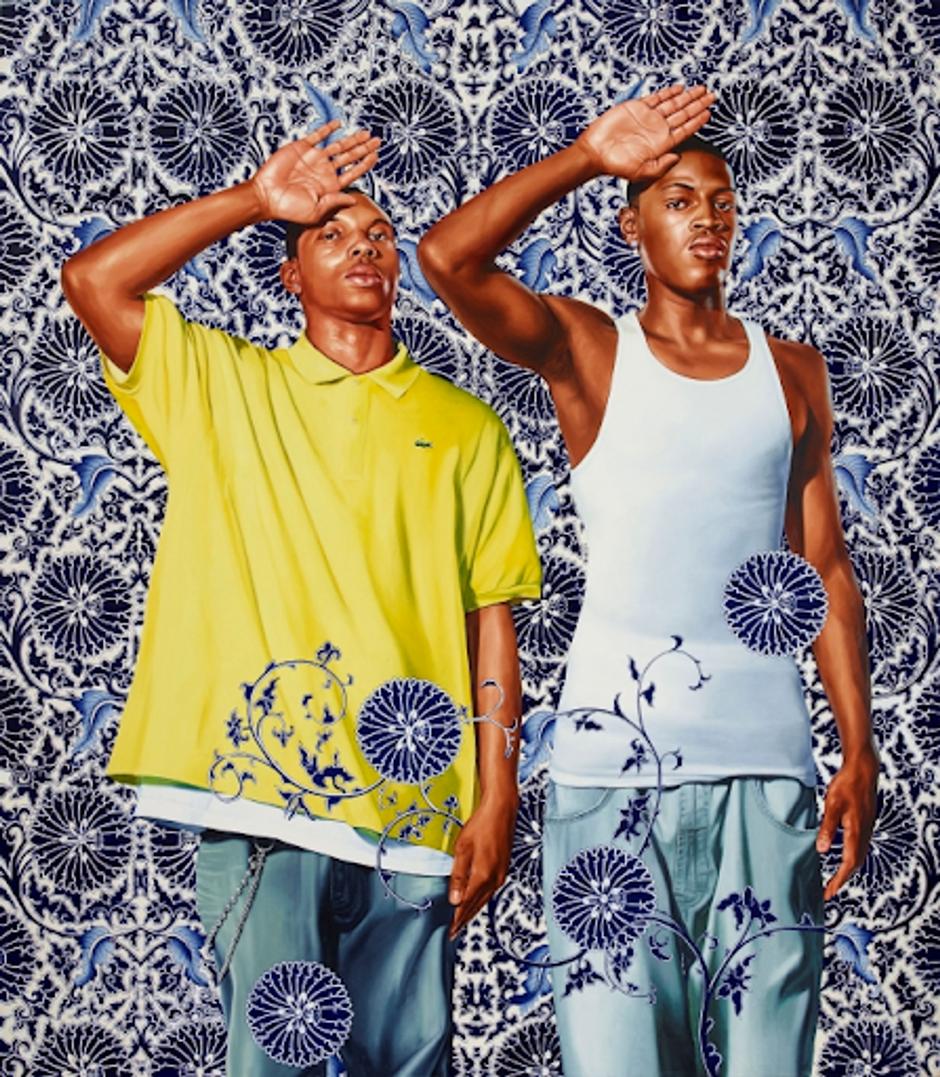Kehinde Wiley’s Two Heroic Sisters of the Grassland. Two black men standing beside one another with one hand raised open on their forehead, and the other hand on the side of their bodies. One wears a yellow shirt, the other  white tank top in front of an ornate blue patterned background. 