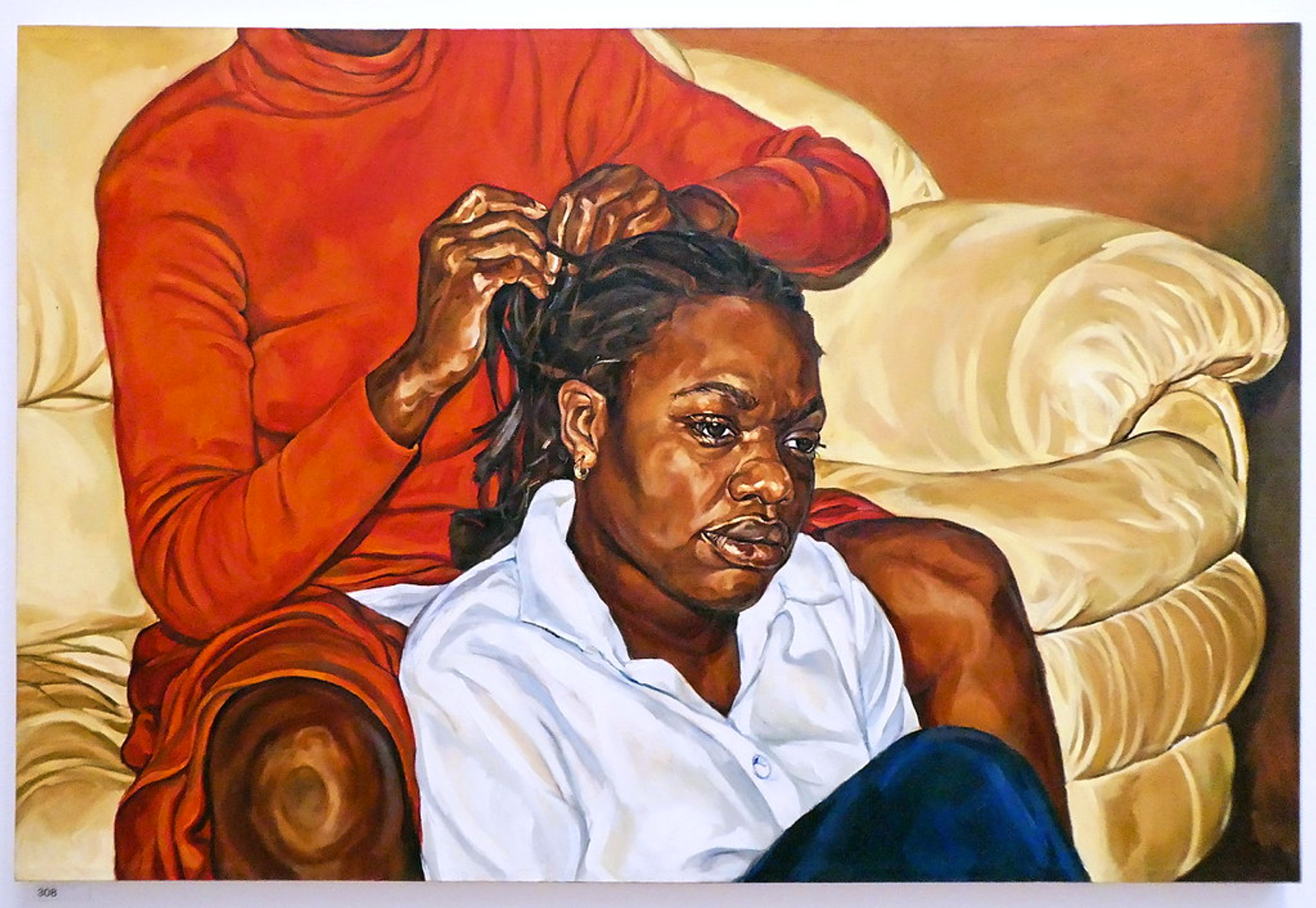 An oil painting by Barbara Walker, showing a black woman sitting on the floor having her hair braided by another black woman who is sitting on a cream couch.