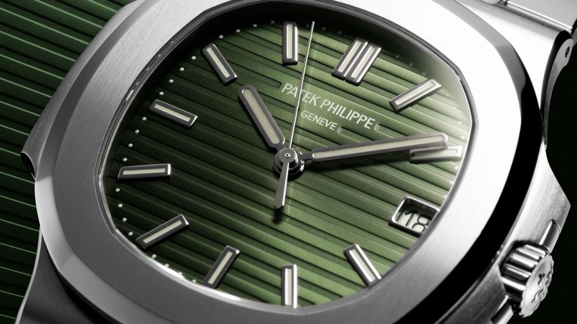 A Patek Philippe Nautilus, first launched in 1976. The image is a close up of the watch face, which is green and set within a silver metal setting.