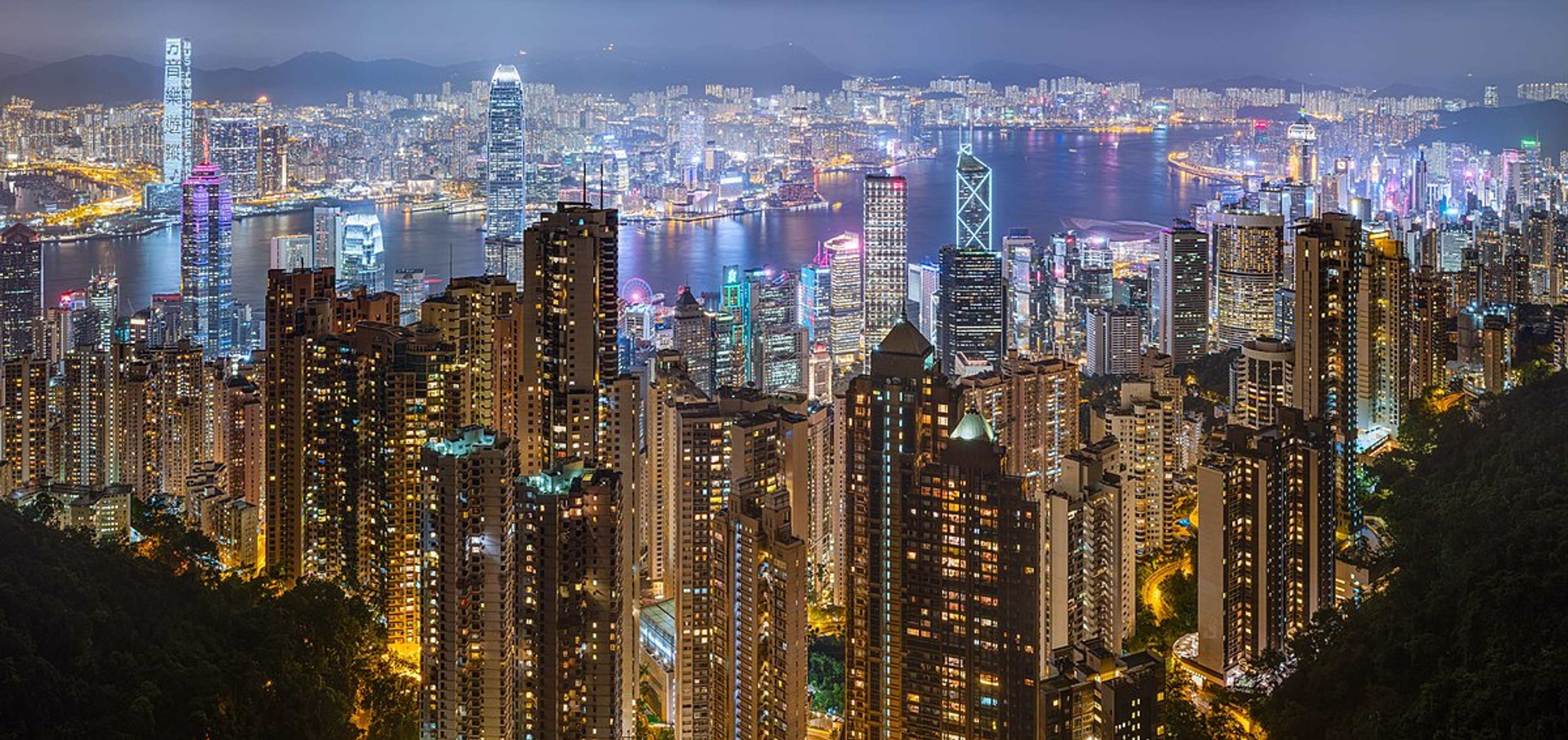 External view of buildings in Hong Kong right next to a river.