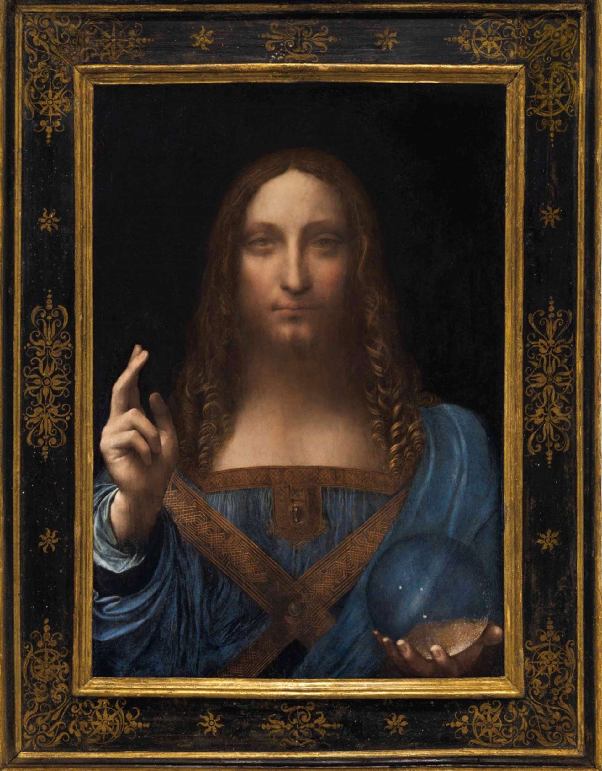 An image of the painting Salvator Mundi, attributed to Leonardo da Vinci. It shows Jesus in a blue dress, holding an orb in his right hand and blessing the viewer with his left hand.