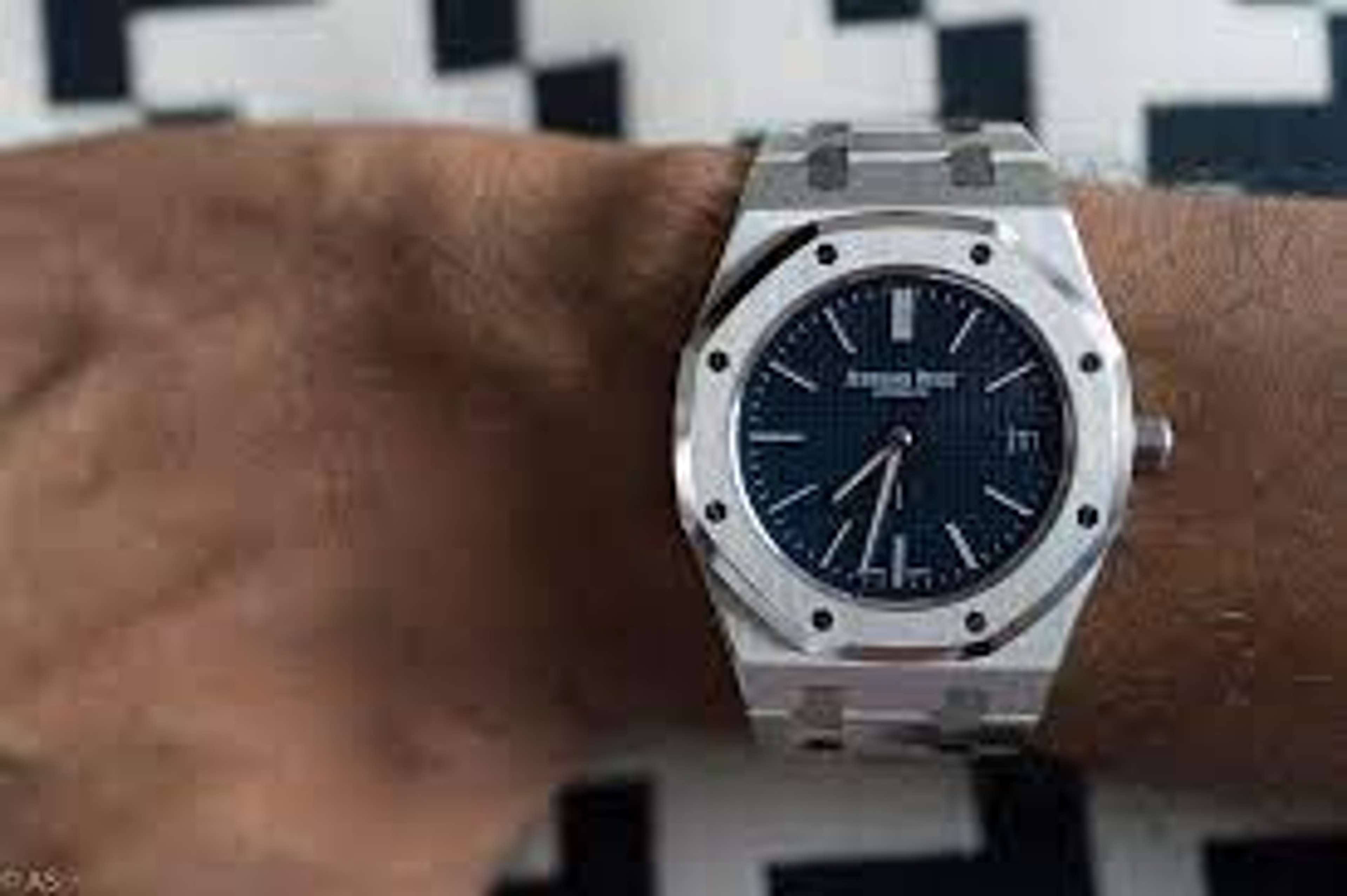 An Audemars Piguet Royal Oak, first launched in 1972. The watch has a silver metal strap and setting, with a black face.