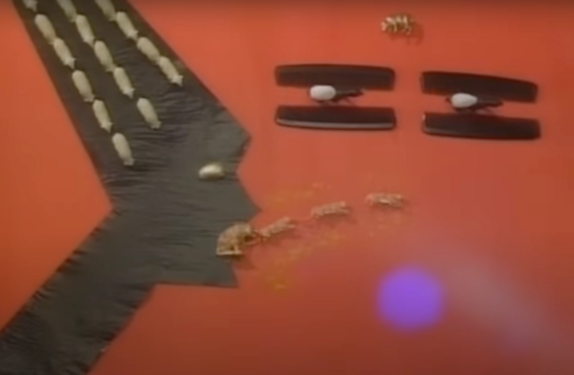 A screenshot of one of Grace Jones' music videos, showing the silhouette of the artist depicted in paper against a red background. 