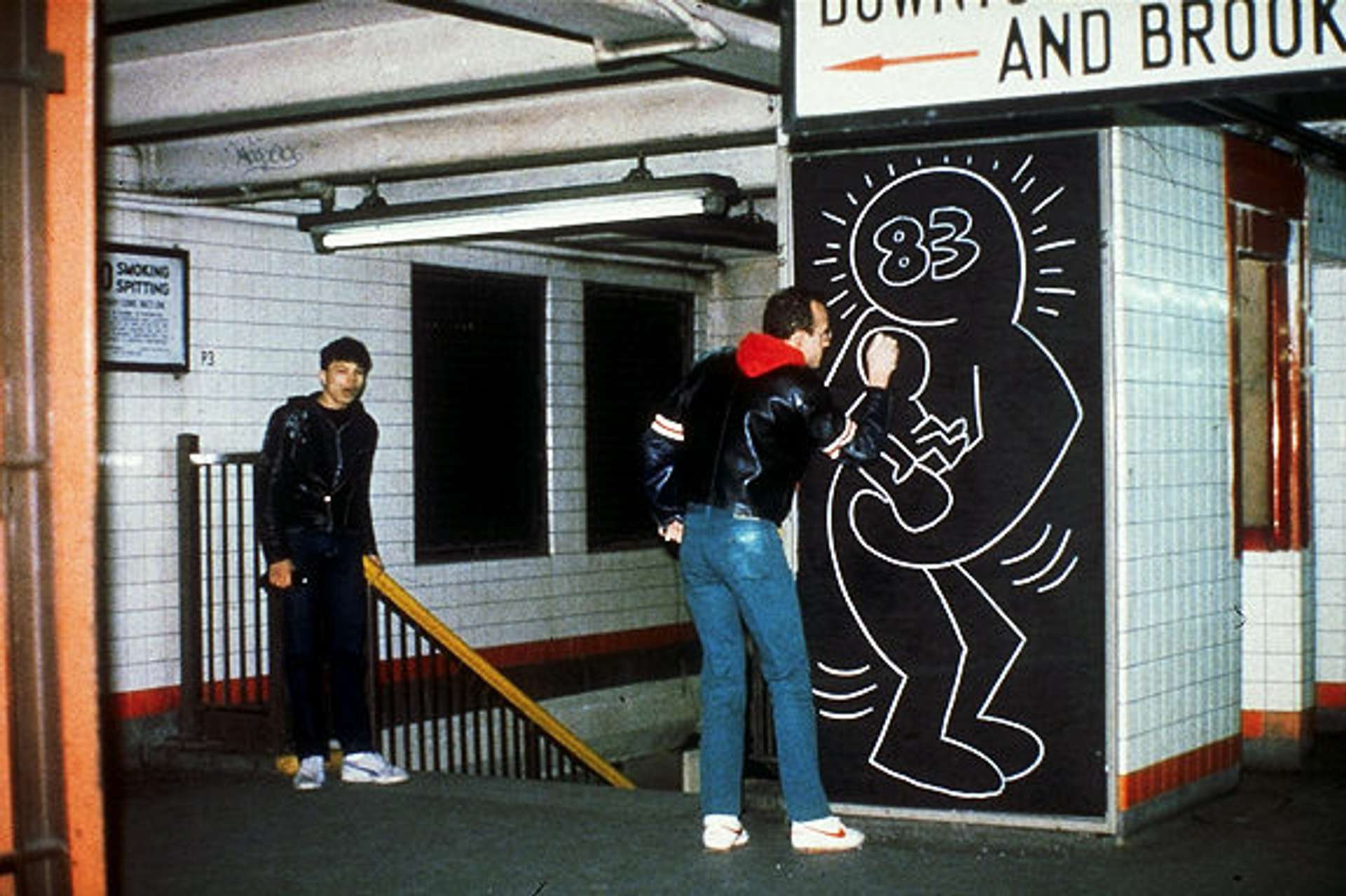Artist, Keith Haring, in the New York Subway graffiti-ing onto a wall