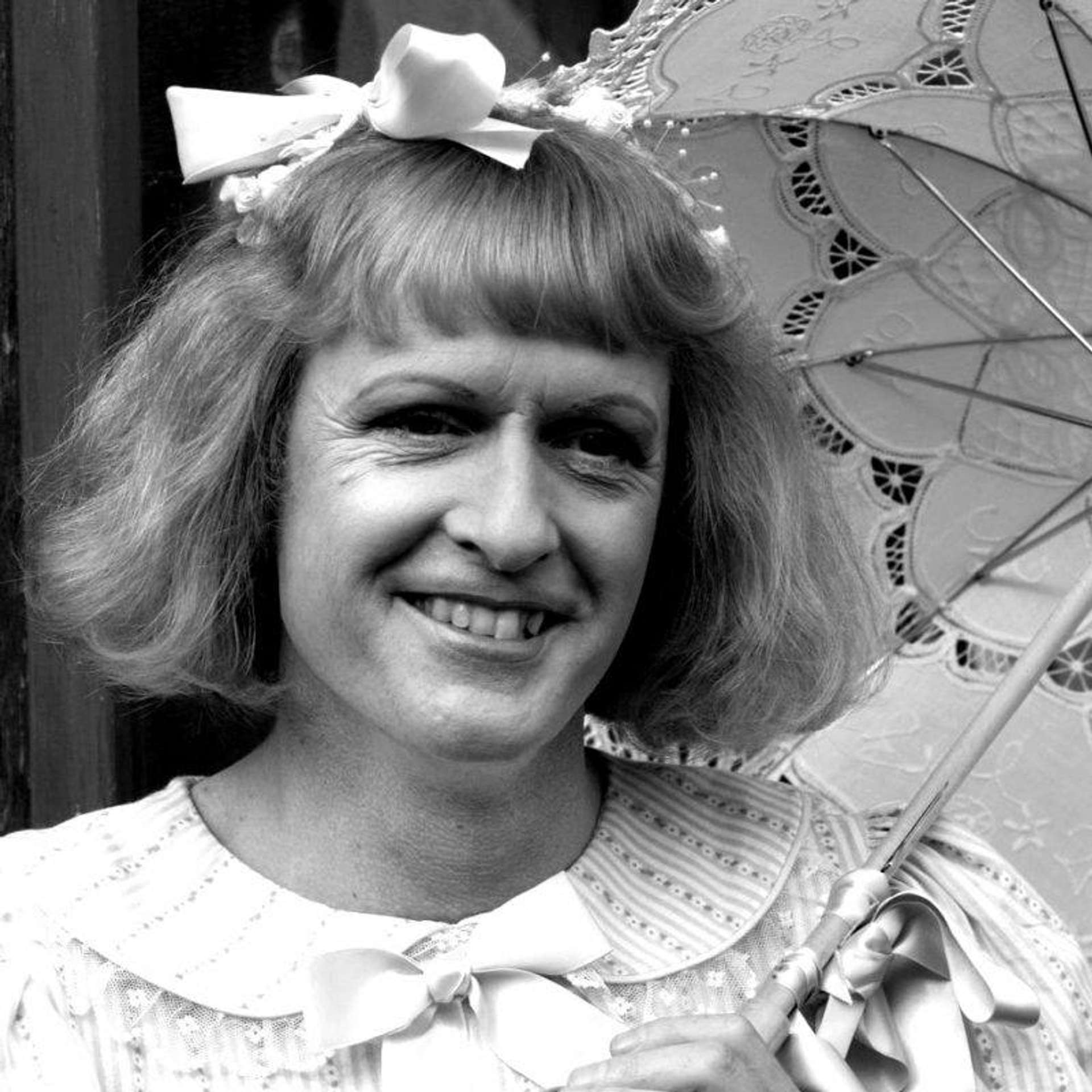 A black and white photograph of Grayson Perry dressed as his alter-ego, Claire.