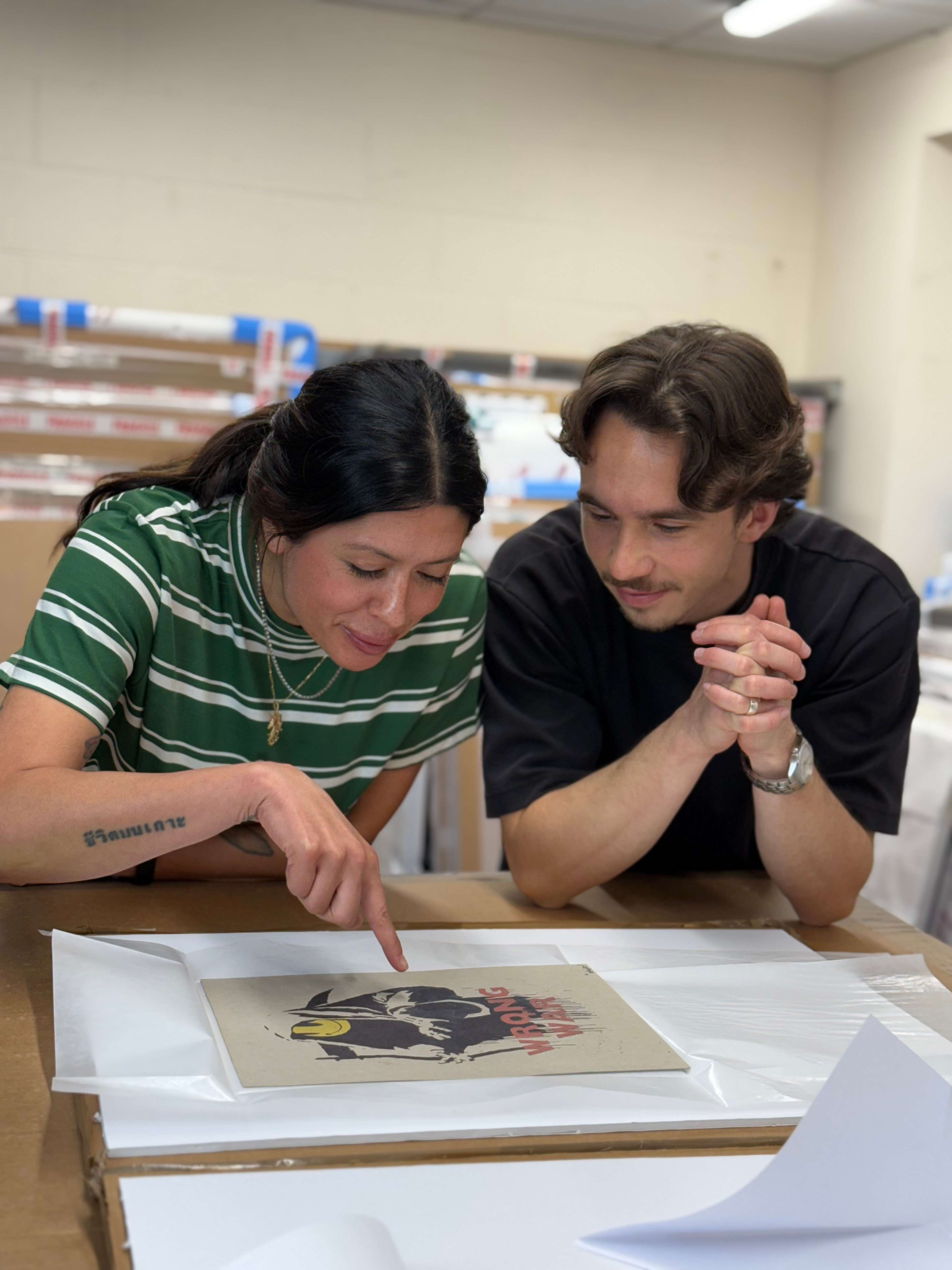 Sheena and Andrei looking at a Banksy print