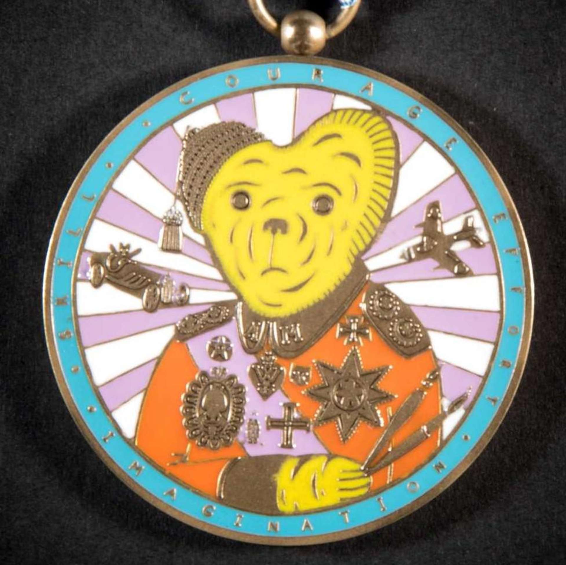A vividly colourful medal, also known as Teddy Bear Medal, portrays the artist’s own childhood teddy bear in the guise of an artist turned war hero, while a radiating pattern emanates from the toy and a plane and car reference wartime.