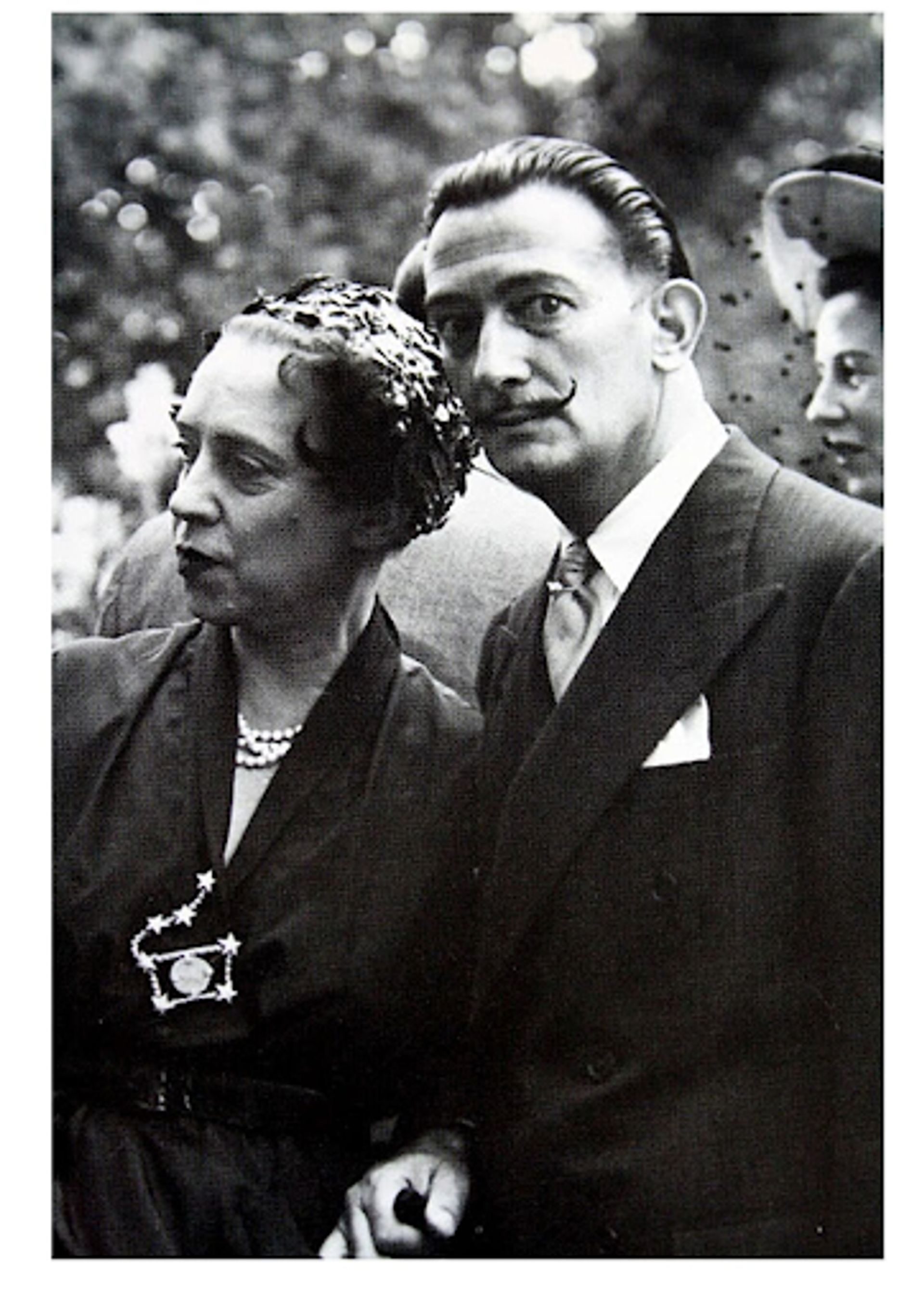 Black and white photograph of Elsa Schiaparelli and Salvador Dalí standing beside one another.