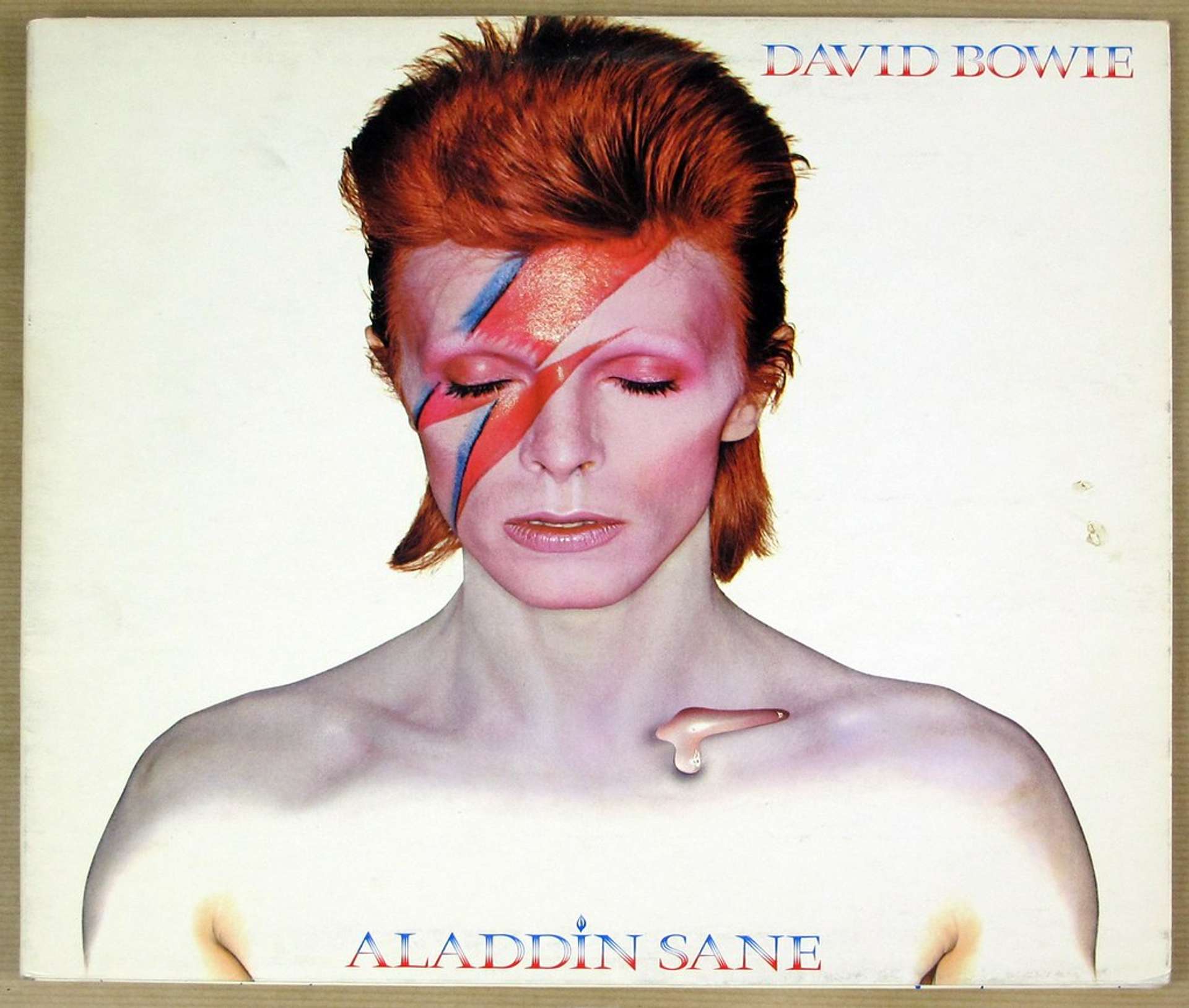 An image of Bowie on the cover of Aladdin Sane in his characteristic makeup, featuring a lightning bolt across his face.