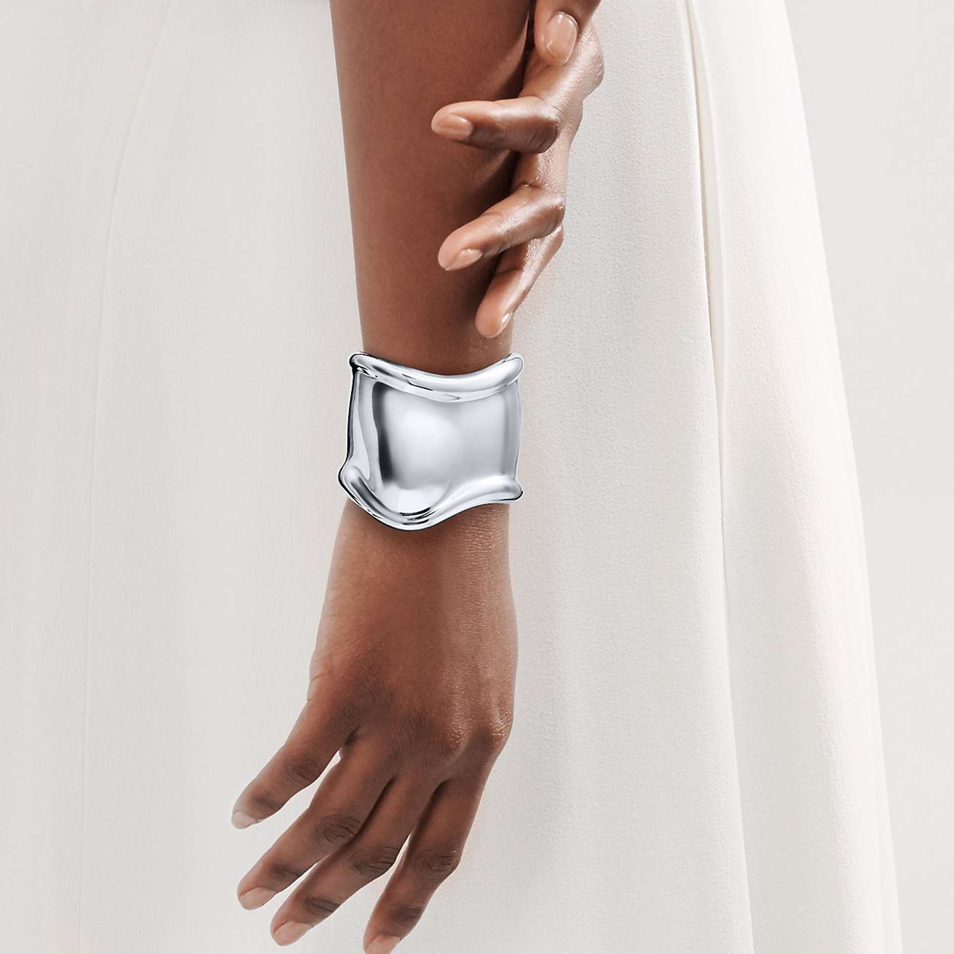 An image of a model wearing a silver version of Elsa Peretti’s Bone Cuff by Tiffany & Co.