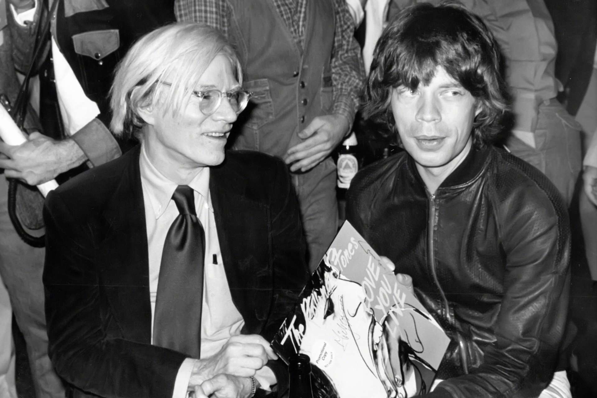 A black and white photograph of The Rolling Stones lead singer Mick Jagger and artist Andy Warhol.