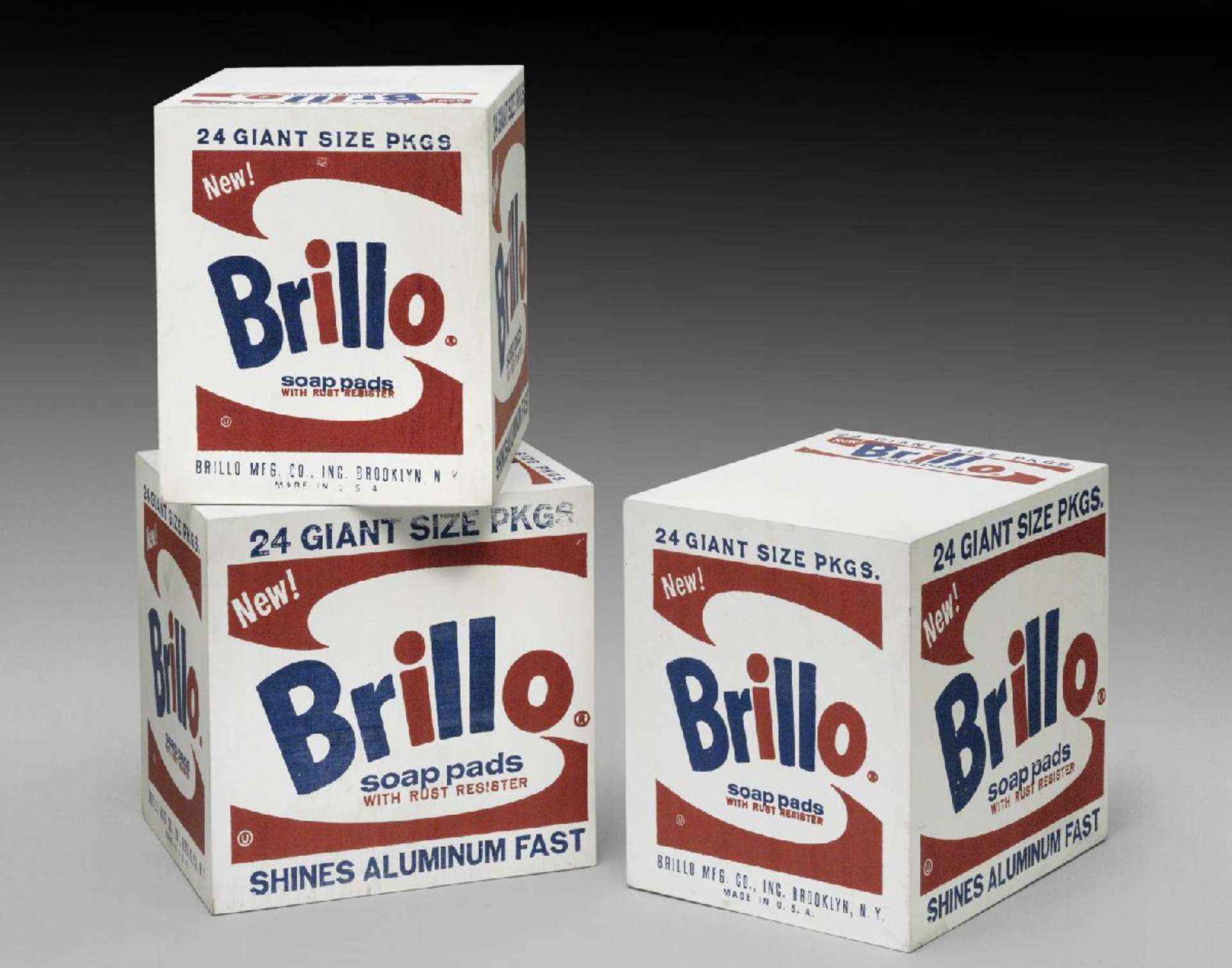 An image of the Brillo Boxes installation by Andy Warhol, featuring three boxes of Brillo soap pads.