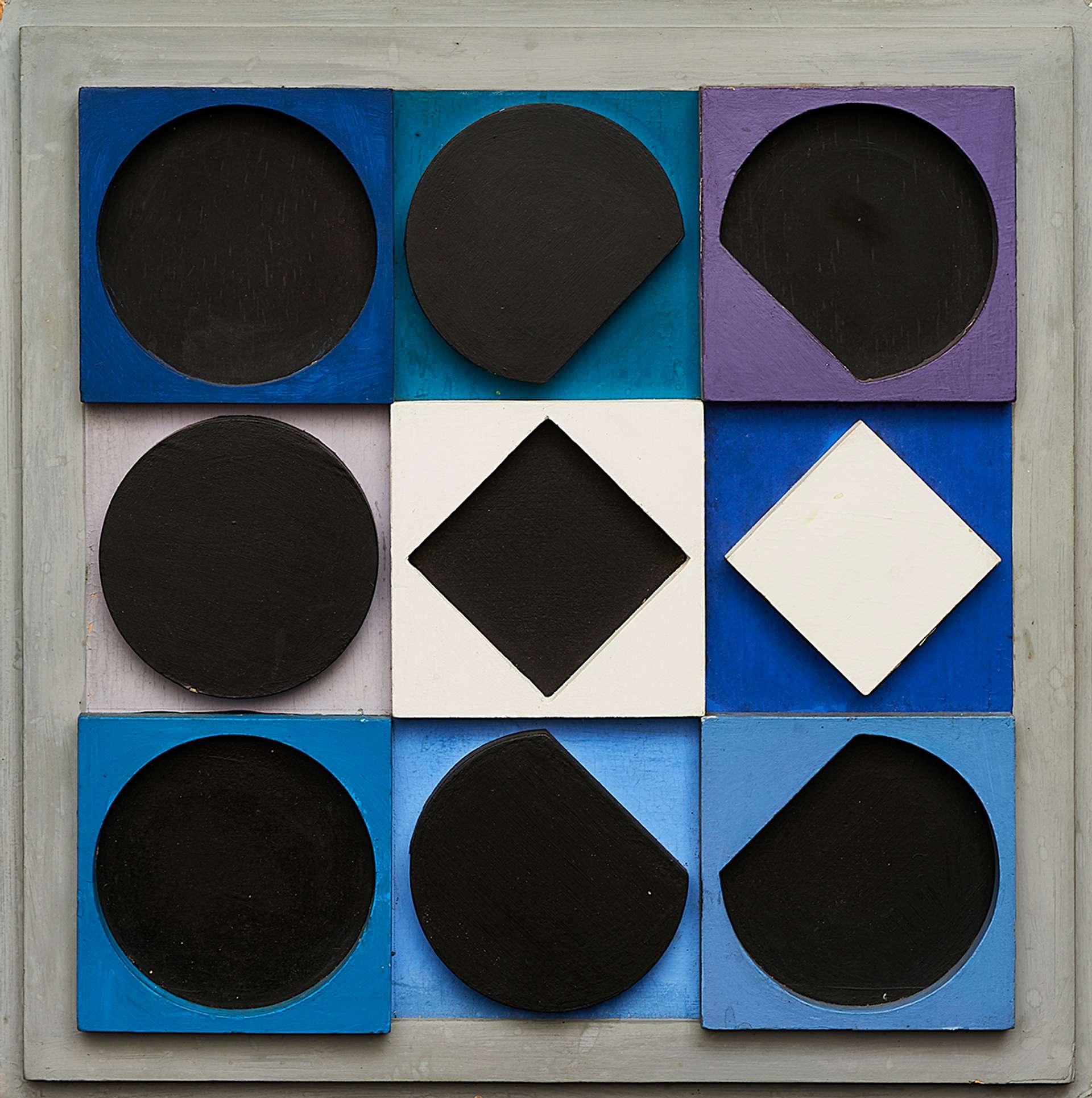 Topaze Noire Negatif by Victor Vasarely (1967). A wooden multiple relief artwork, featuring circular shapes and squares on a grid, in blue, shades, purple, black and white.