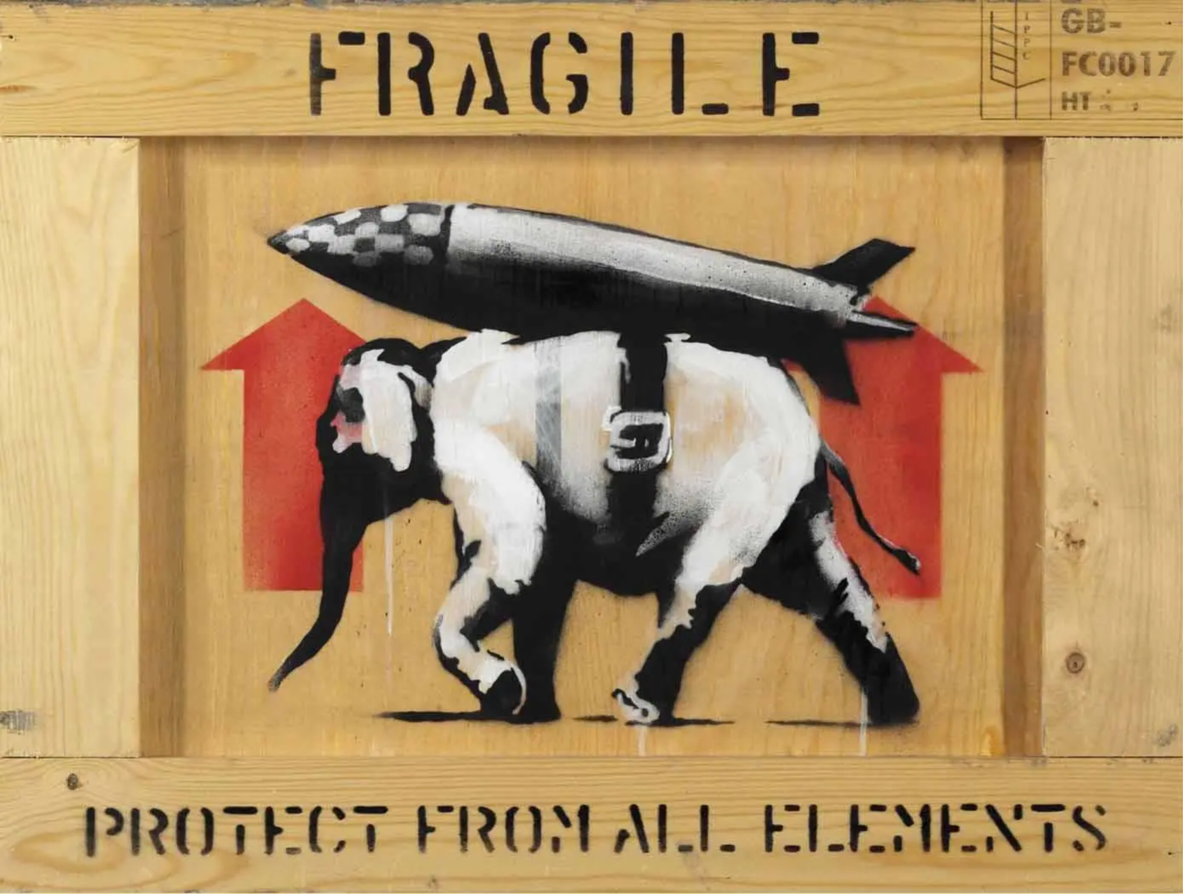 This work by Banksy, done on the side of a wooden crate, shows a stencilled elephant wearing a missile strapped onto its back. The words Fragile and Protect From All Elements frame the animal.