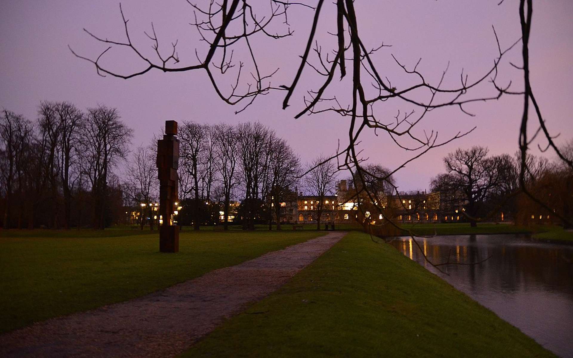 Night view of the Backs of Trinity College, Cambridge with the sculpture Free Object by Antony Gormley in January 2018.