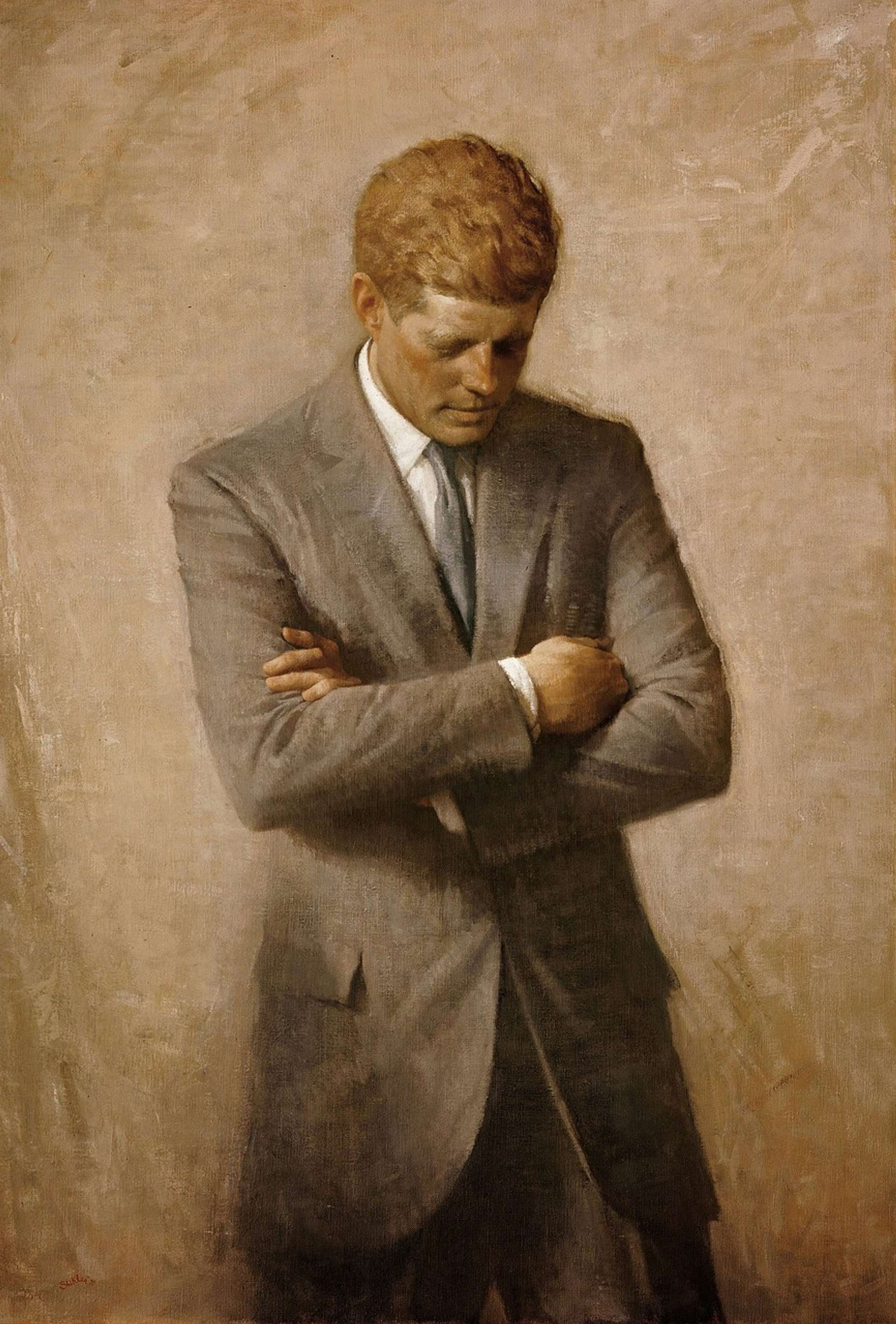 A portrait by Aaron Shikler of President John F. Kennedy standing with his head down, and arms folded. He is wearing a grey suit against a tan background.