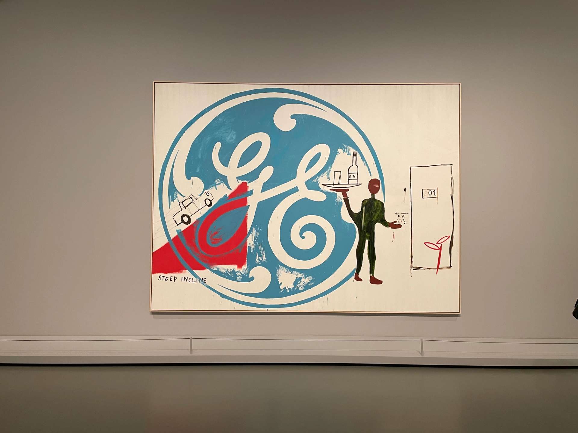 Installation view of Painting Four Hands. A large blue General Electric logo artwork