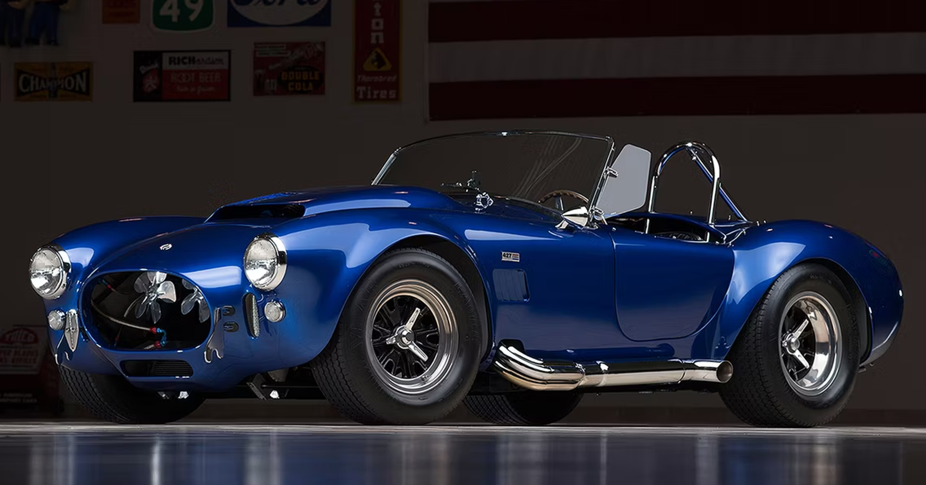 L'unique Shelby Cobra 427 de 1966. La voiture bleu électrique est photographiée sur un fond sombre.