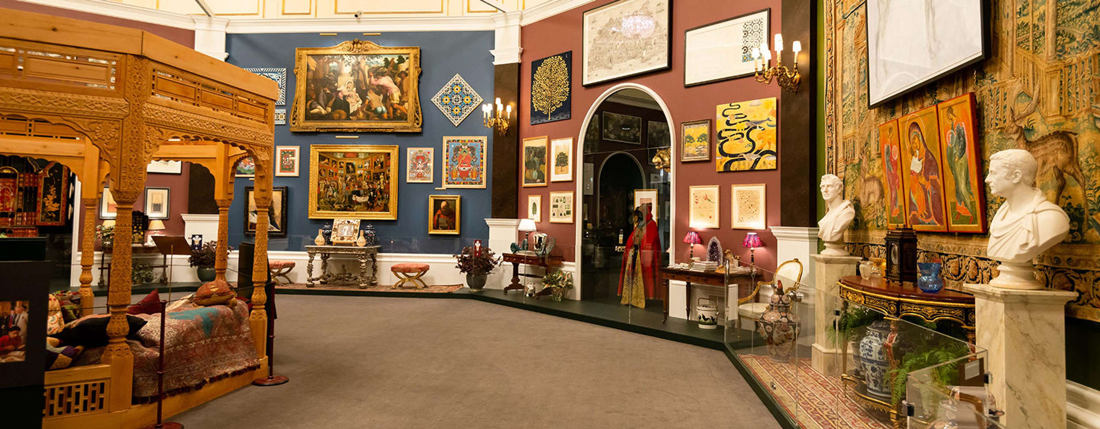 Une photo de l'exposition « Prince & Patron », organisée par l'alors Prince Charles au palais de Buckingham. L'image présente un grand nombre d'œuvres d'art et d'objets, notamment des peintures, des sculptures et du mobilier.