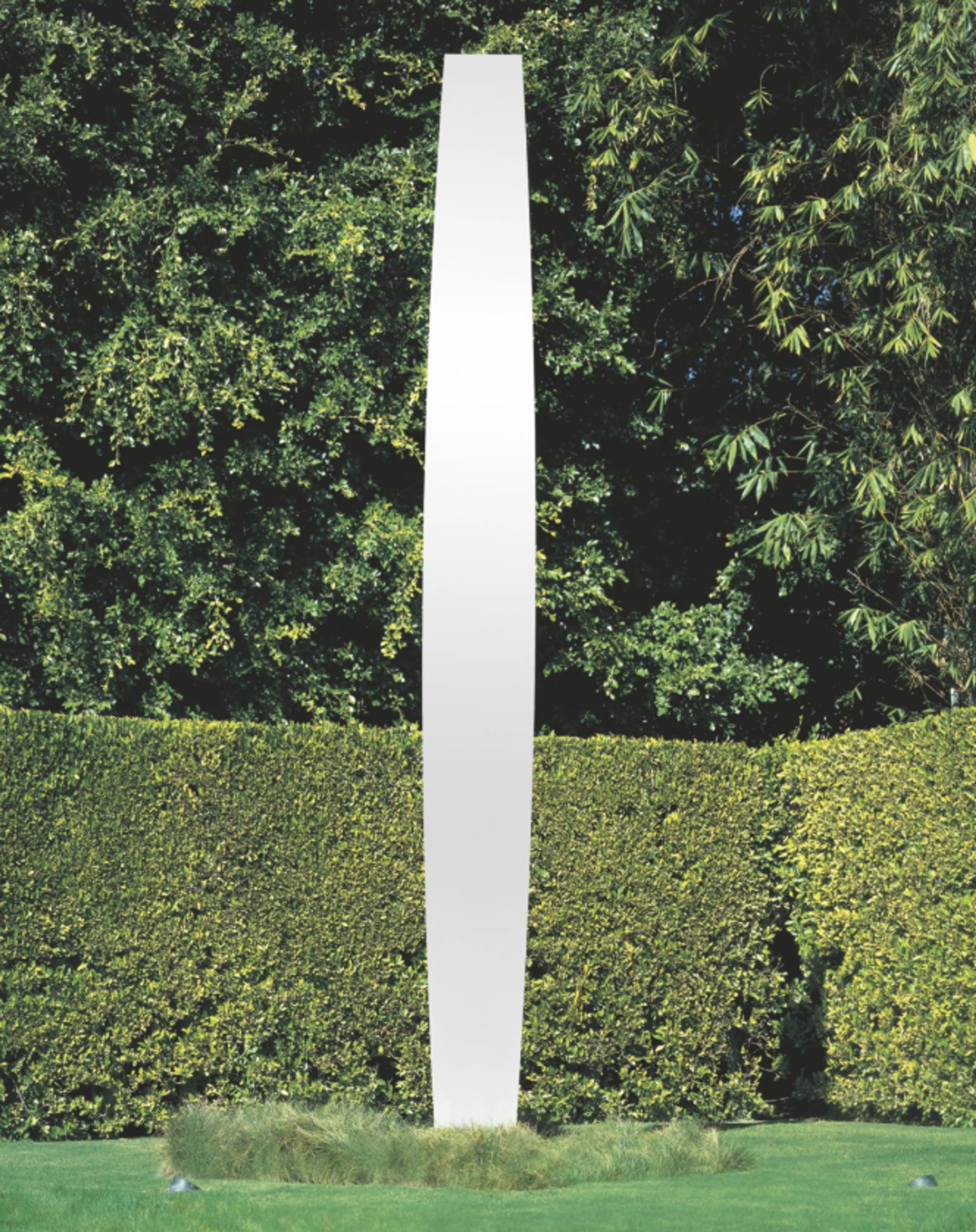 A tall stainless steel totem with a perfect polished finish. It stands at nearly 5.5 metres tall, and only 55 cm wide at its widest point. Its sides curve slightly, making it wider in the middle than at the top and bottom.