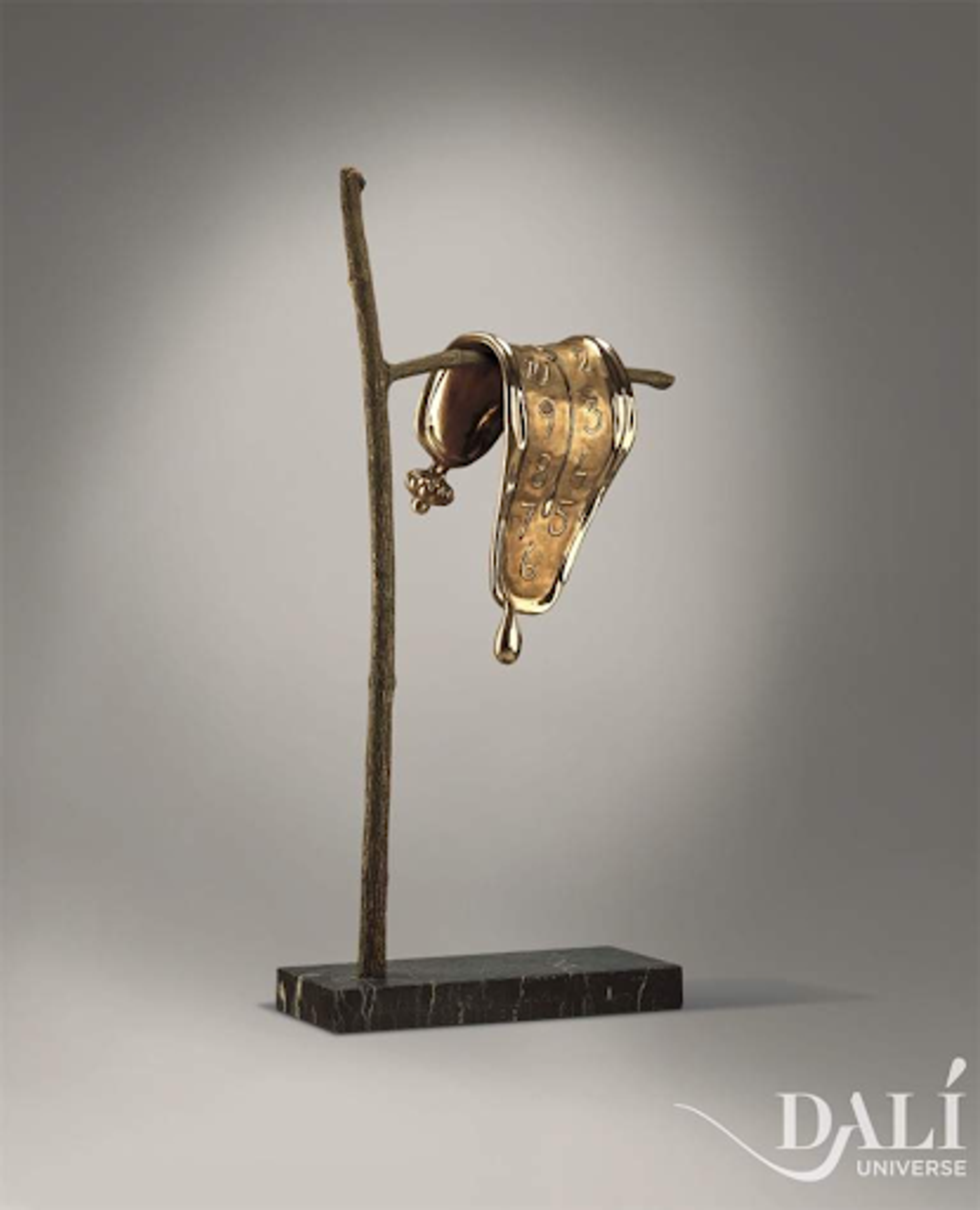 « Persistence Of Memory » de Salvador Dalí. Une sculpture en bronze représentant une horloge déformée drapée sur une branche.