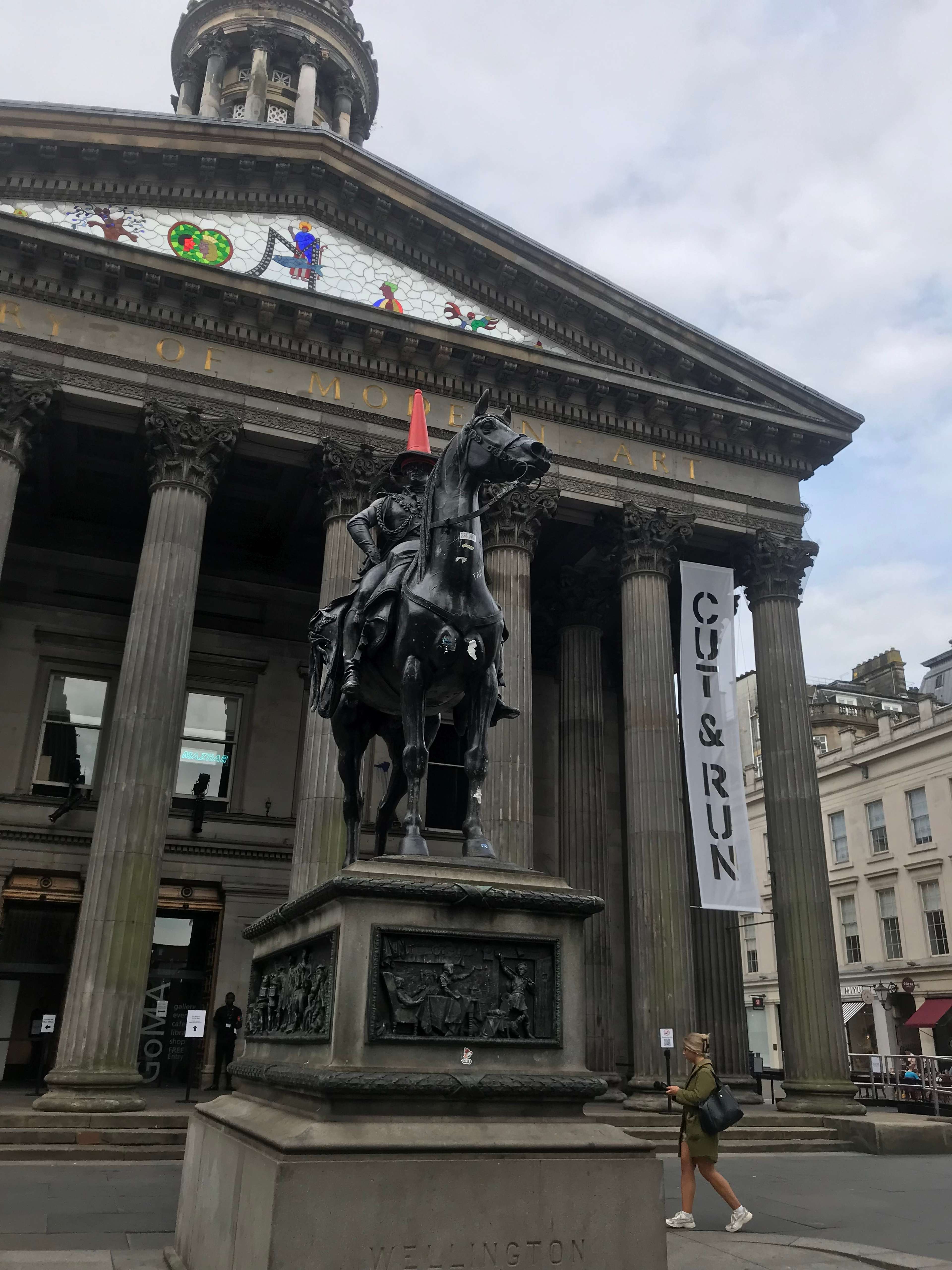 Une photographie de la tristement célèbre statue du duc de Wellington devant le GoMA, qui est vandalisée avec un cône de signalisation depuis des décennies.