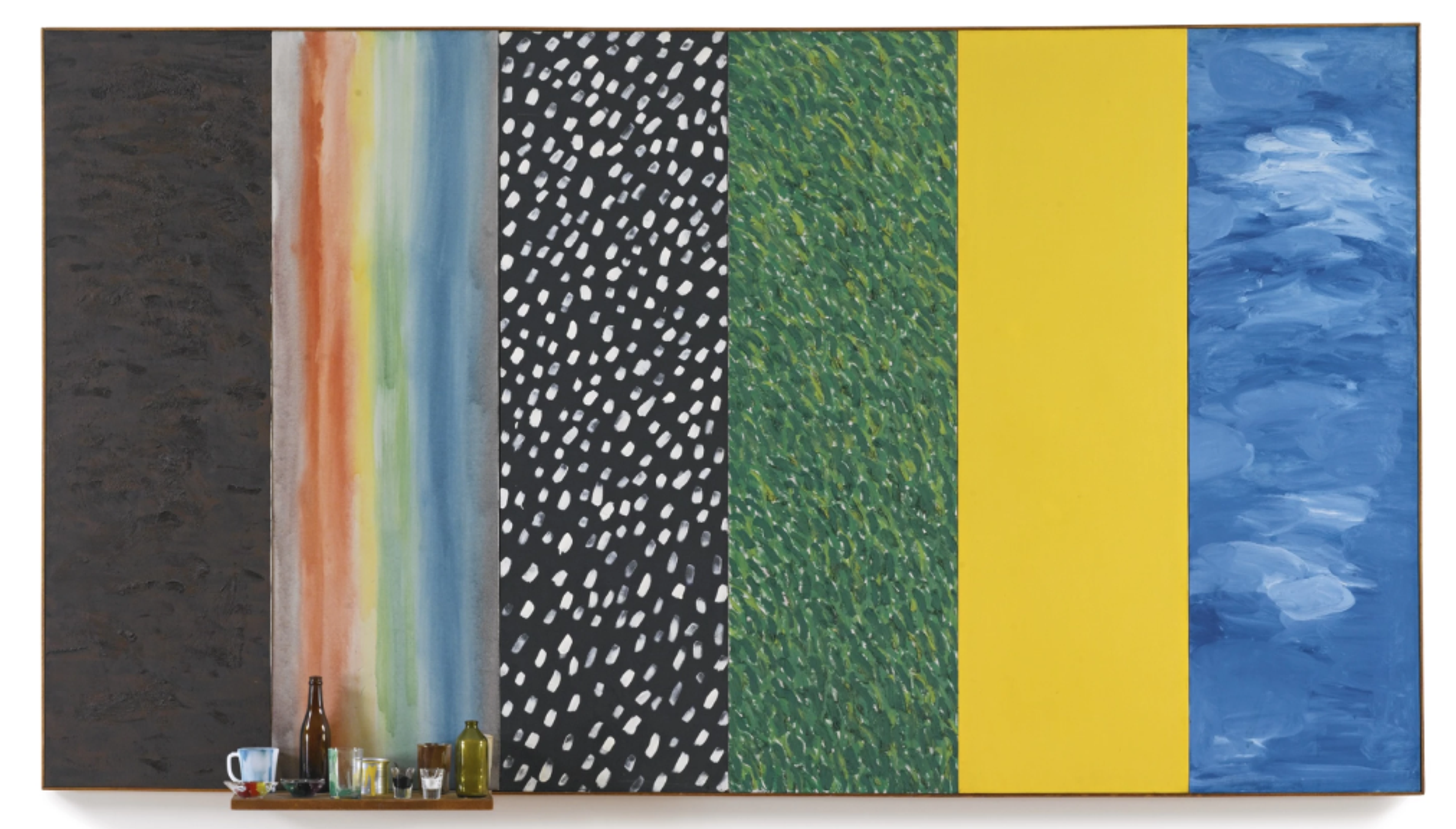 A wide canvas divided into six vertical sections, each with a new colour and texture. From left to right, the sections are: texture black, smudged rainbow stripes, black with white spots, green grass, bright yellow, and painterly abstract blue sky. Attached to the bottom of the rainbow section is a wooden shelf holding a bottle, a mug, and various small glasses and jars.