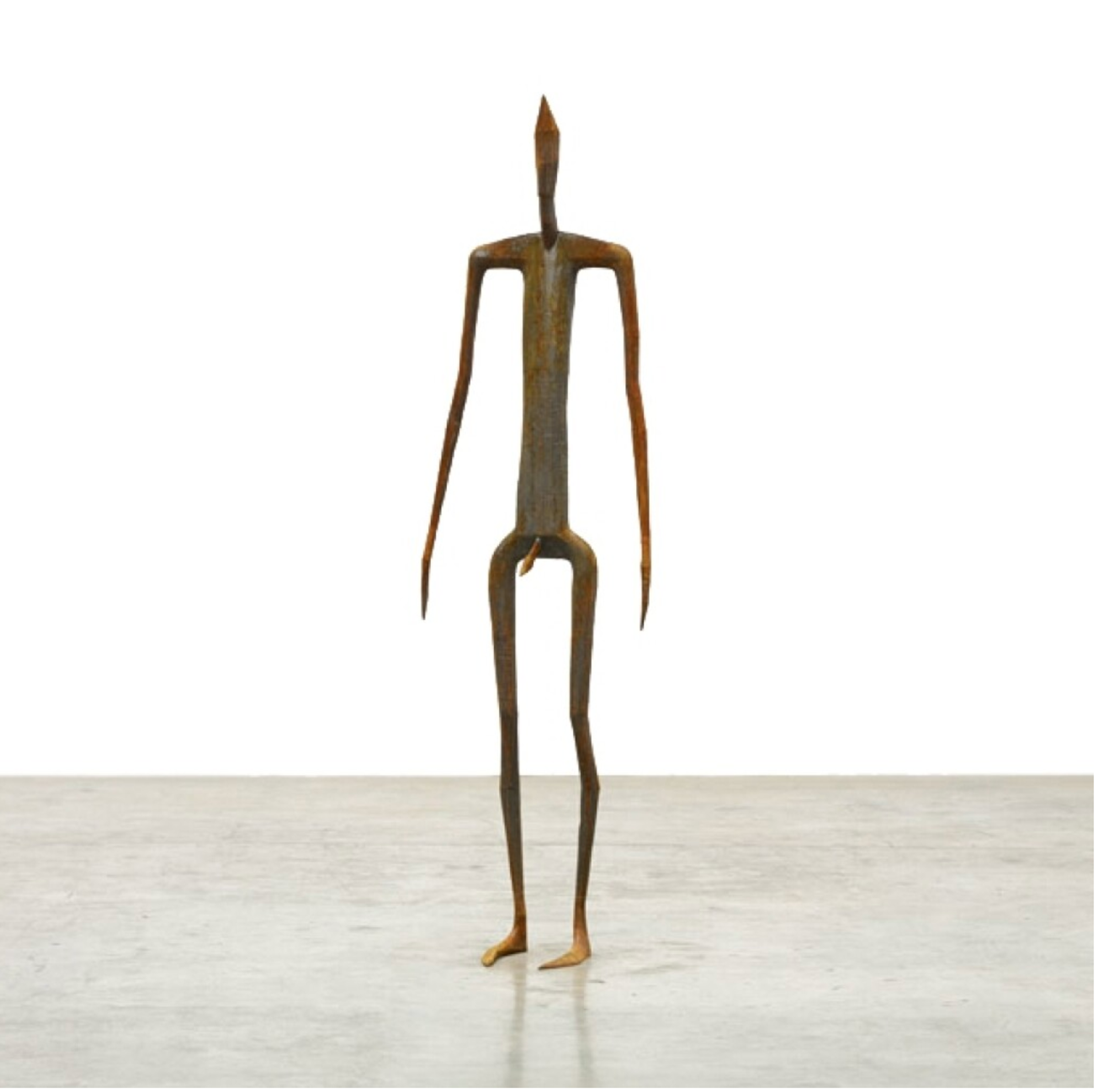 Une sculpture en fonte aux contours schématiques représentant une figure humaine debout.