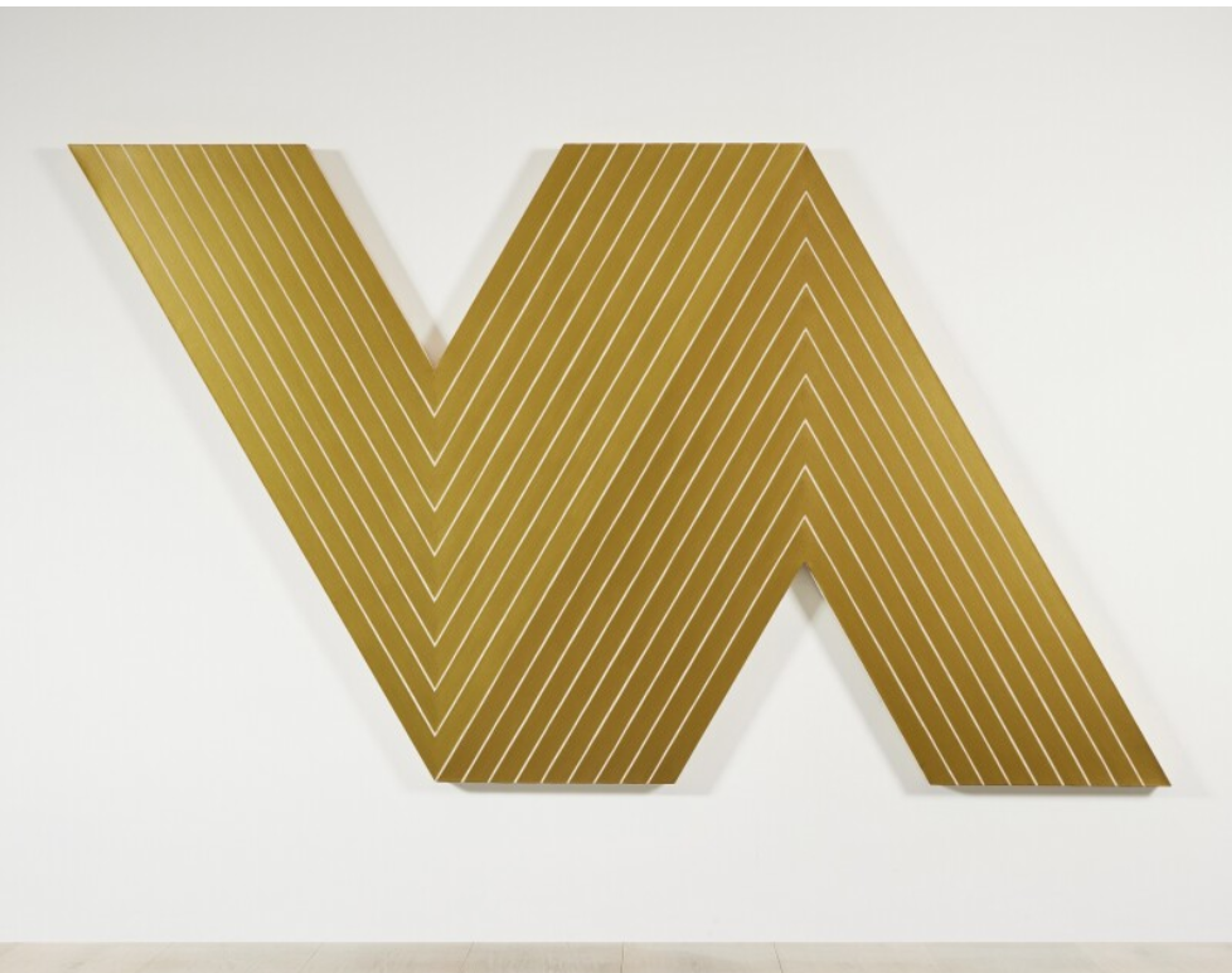 A sculptural relief resembling two golden "V" shapes, one of which is inverted. Thin white parallel lines follow the shapes. 