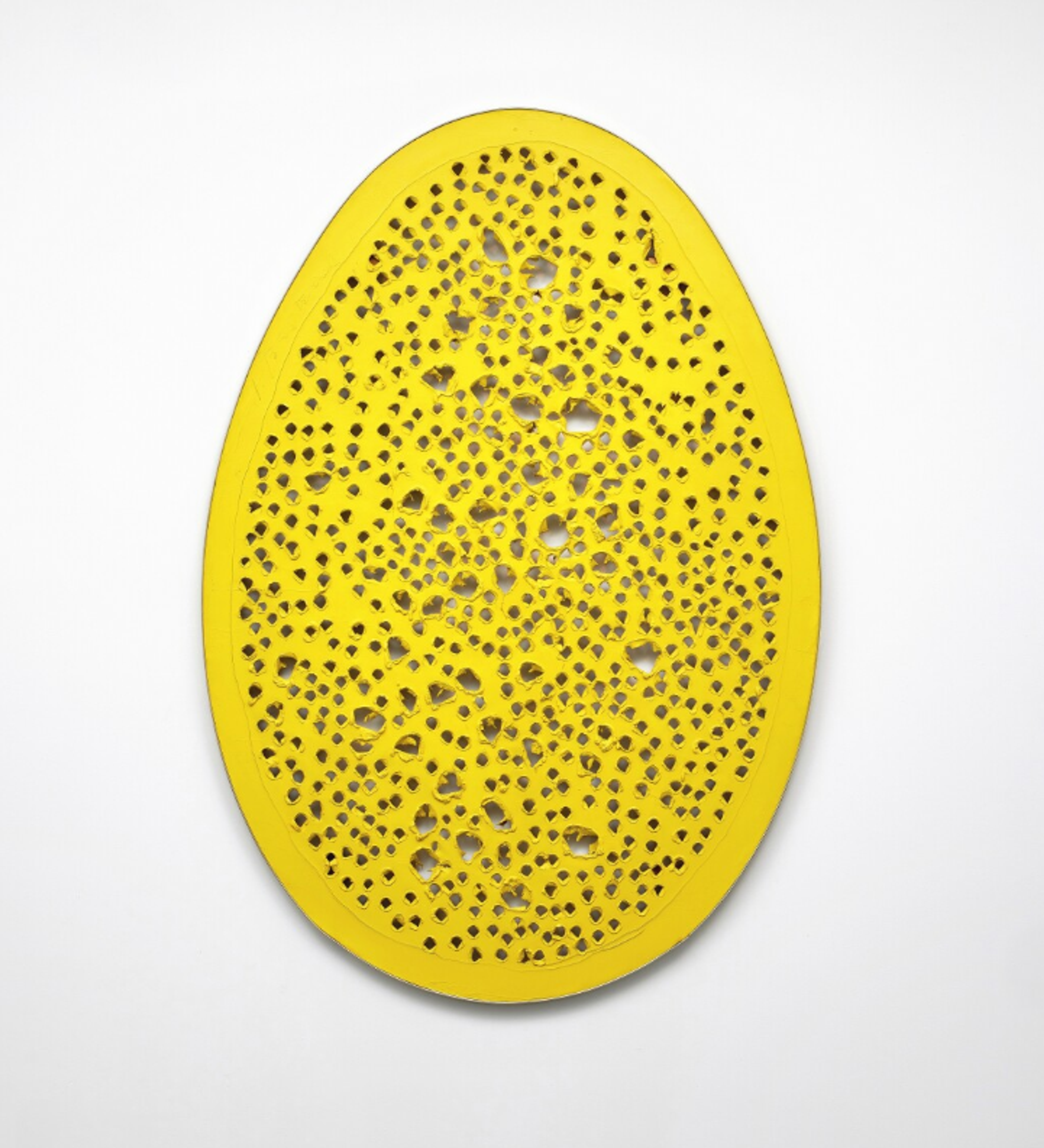 A yellow egg-shaped canvas almost entirely covered with small perforations, apart from a border around its edge.