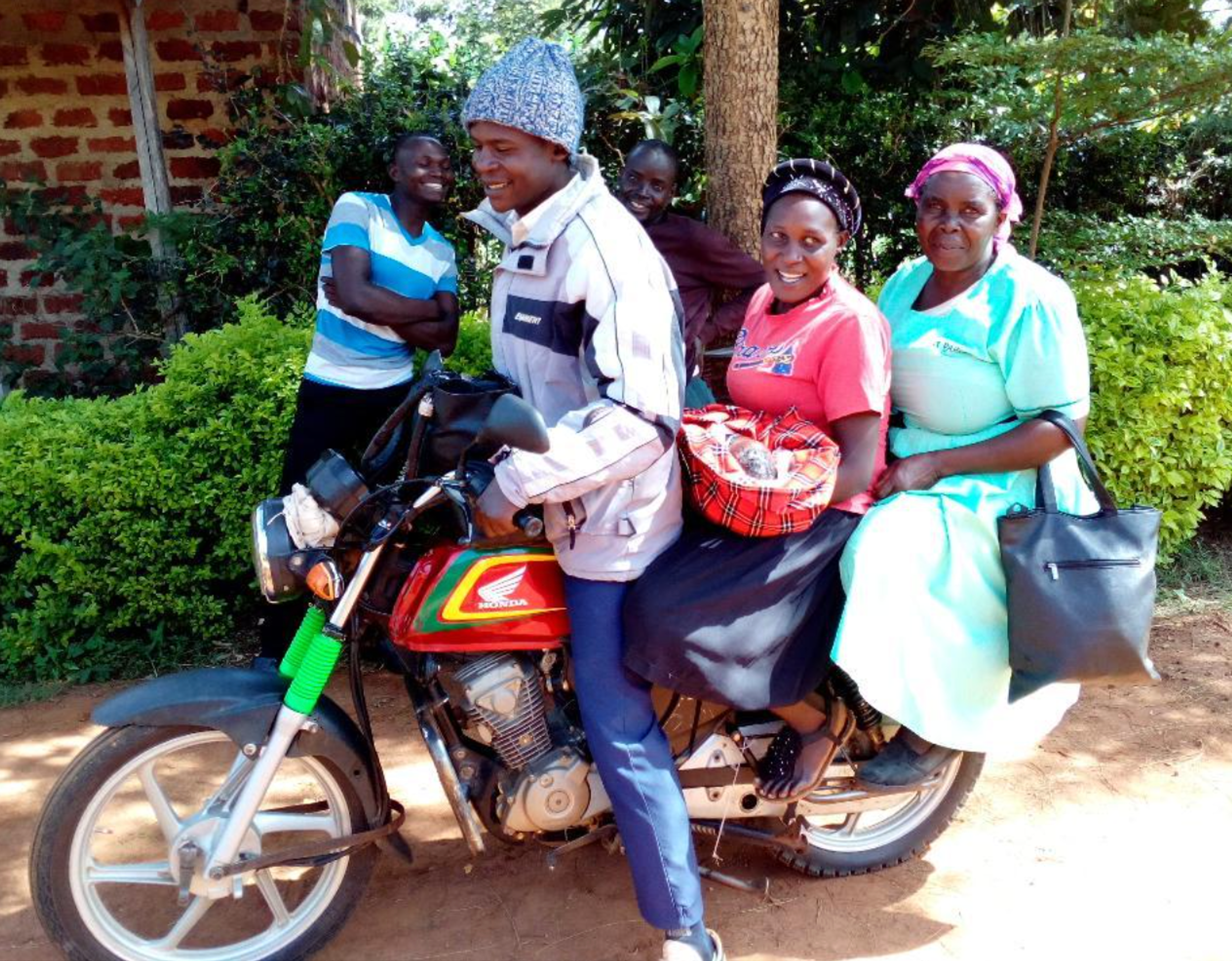 Un nouveau-né rentre à la maison ! Le bébé n'a que 14 heures ! Il voyage en taxi moto avec la mère, le bébé et l'Accoucheuse traditionnelle sur le deux-roues. Le trajet dure environ 40 minutes sur des routes très accidentées.