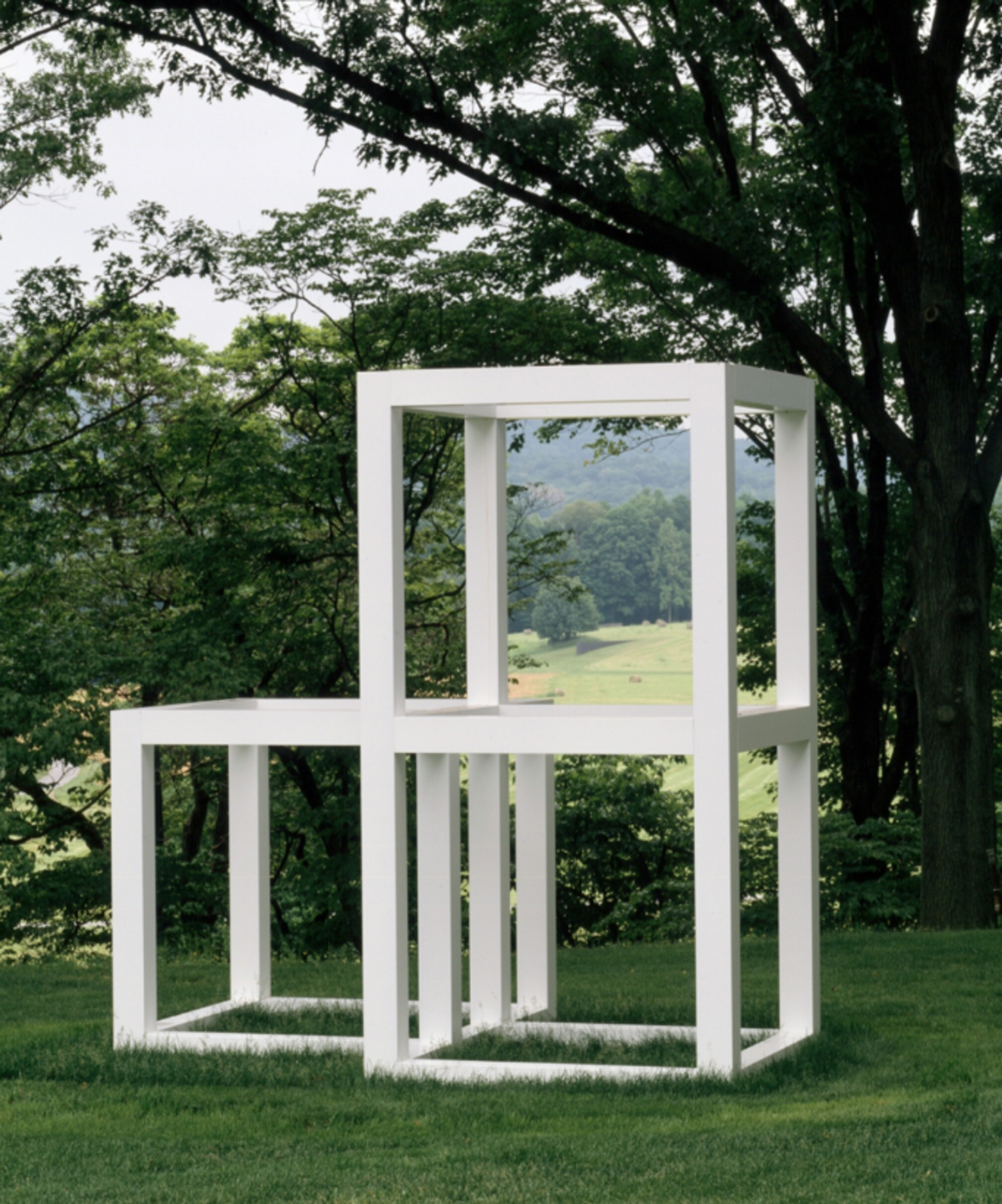 A white structure comprising three open cubes. Two are placed on top of each other, with one to the left slightly further back.