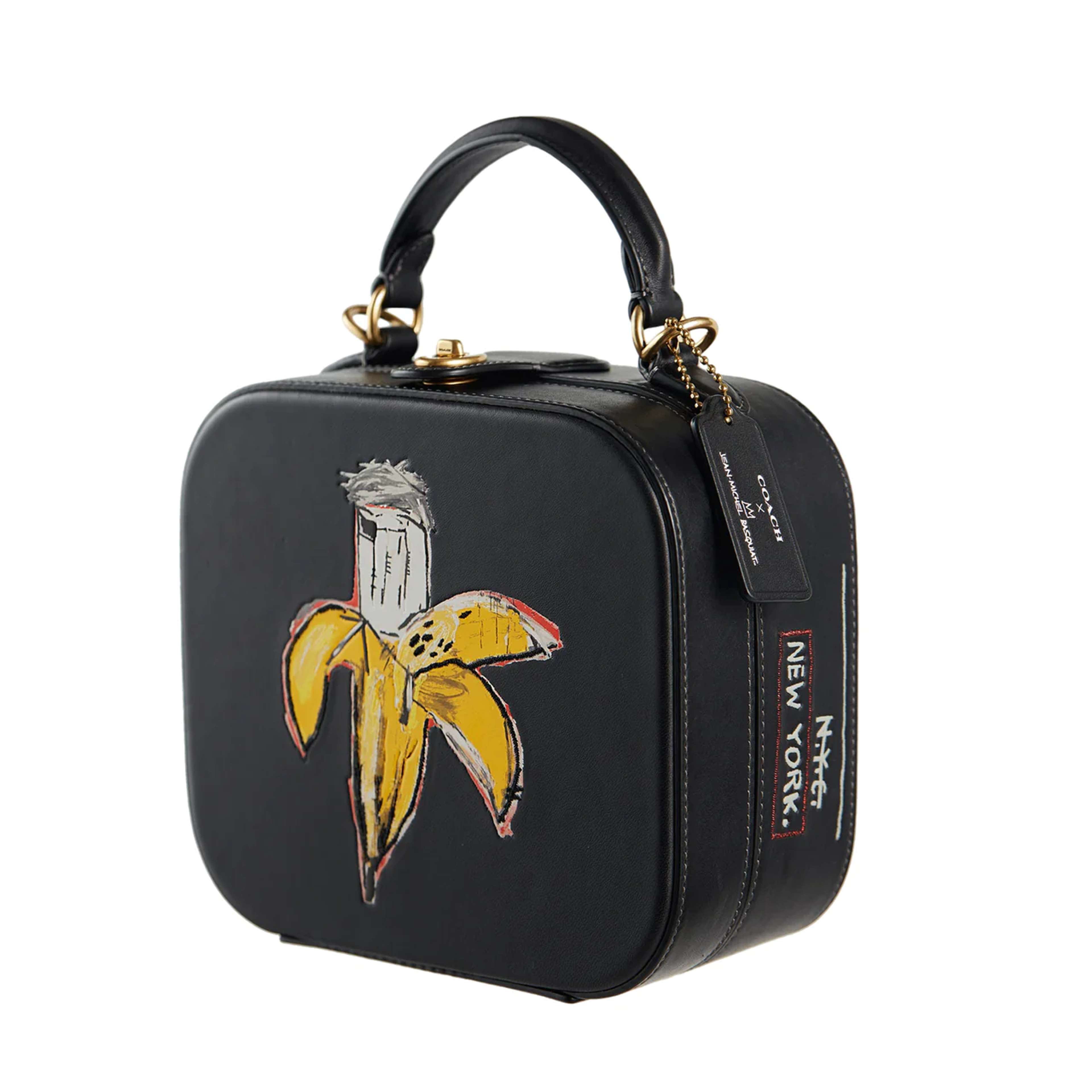 Un sac à main noir de forme carrée orné d'une peinture de Jean-Michel Basquiat représentant une banane