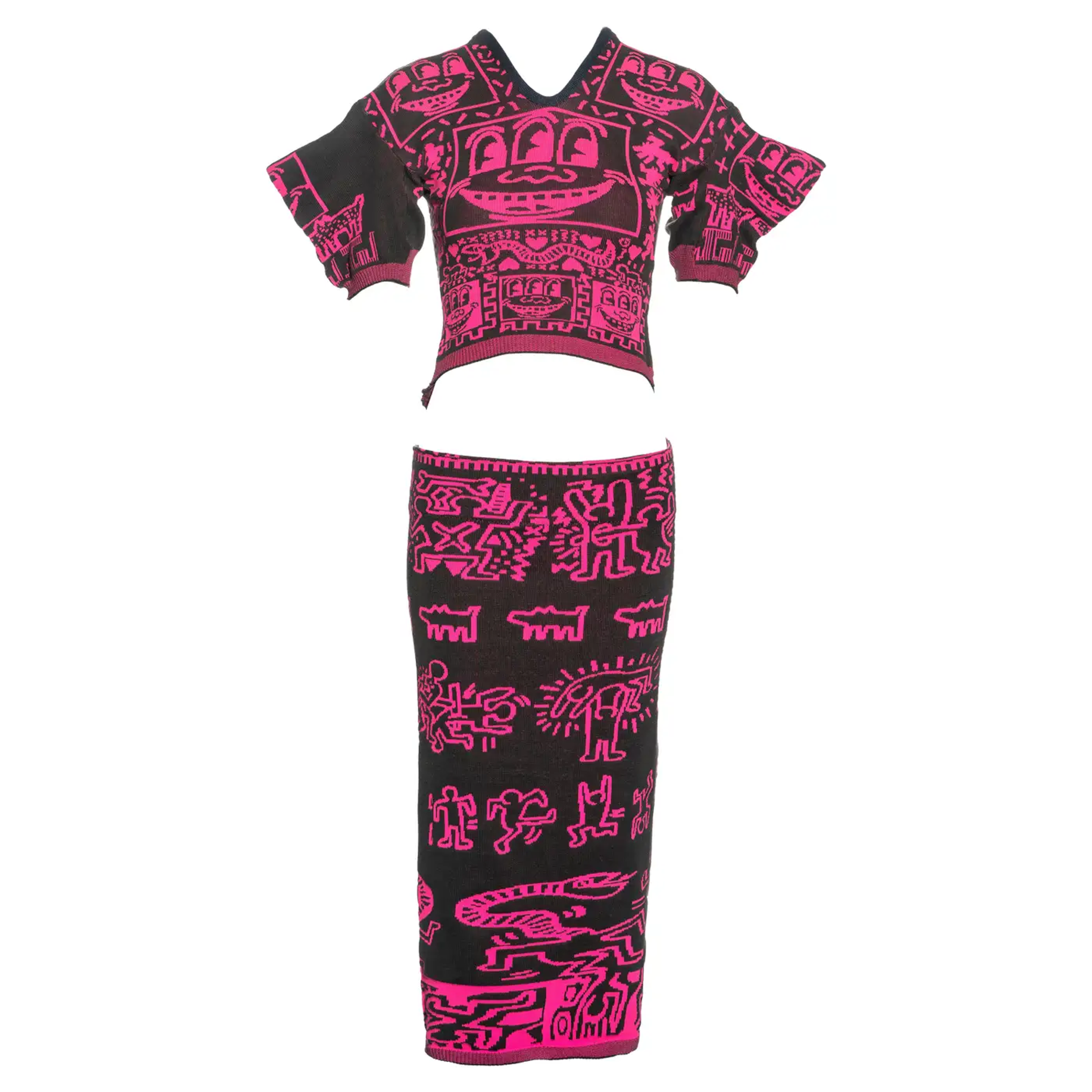Cette image montre un mannequin portant un ensemble assorti de jupe et de pull en maille, ornés de motifs néon de Haring sur fond noir.