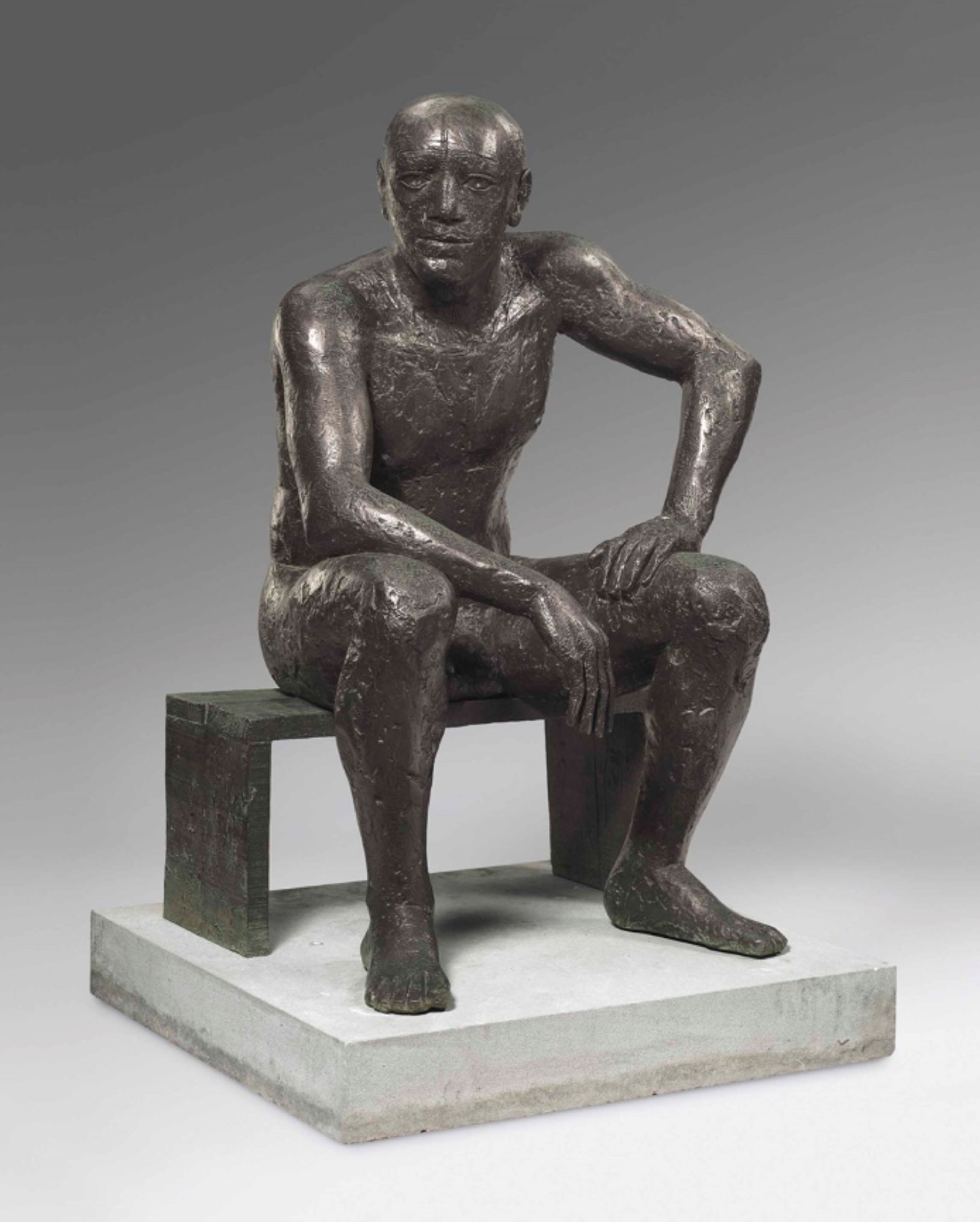 An expressive, almost primitive bronze sculpture of a man seated on a very simple geometric bench. He leans forward to the right, resting his right elbow on his right thigh, and propping his left hand up against his left thigh. His features are large and rounded.