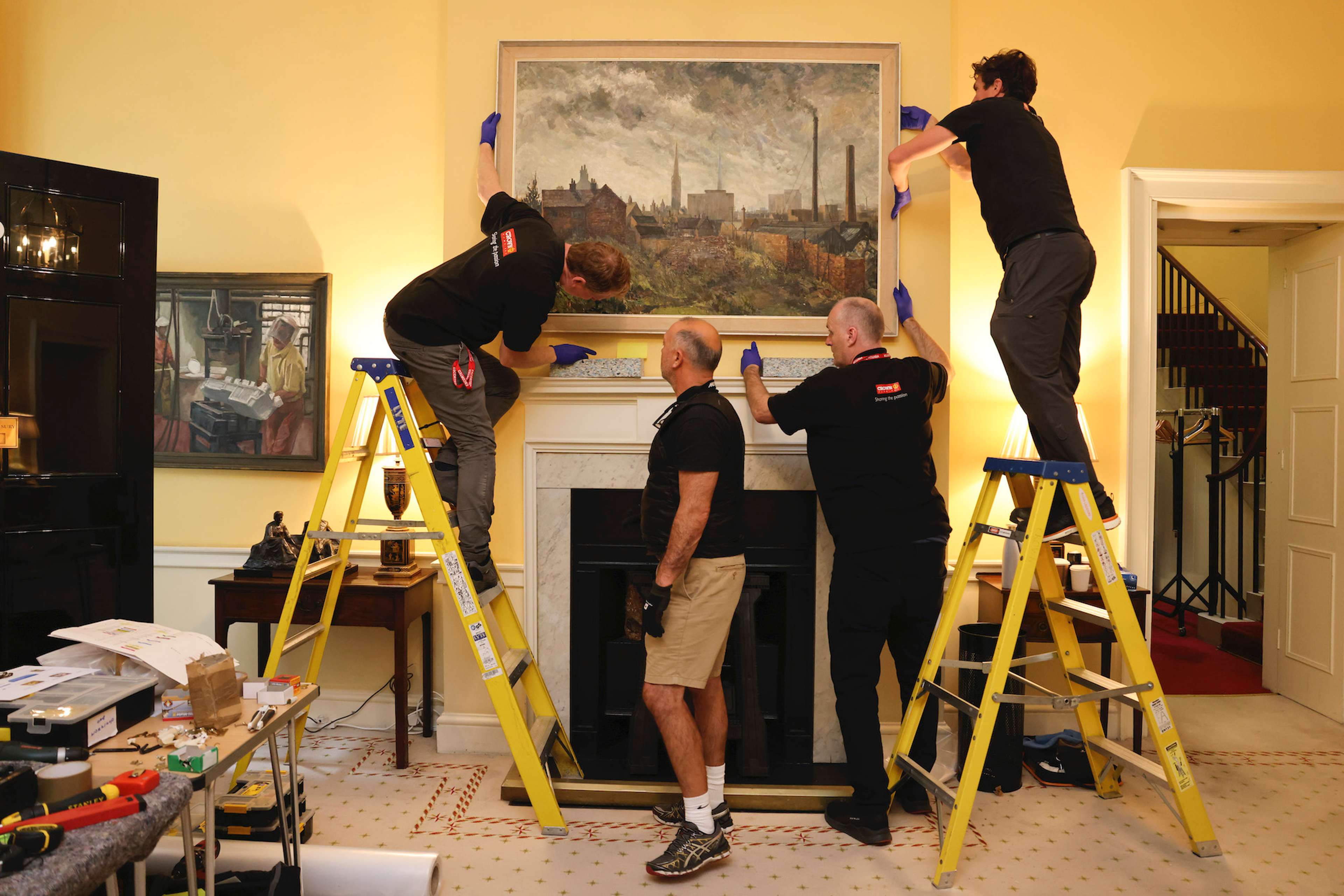 Image d'installation montrant une peinture en cours d'accrochage sur un mur à l'intérieur de Downing Street