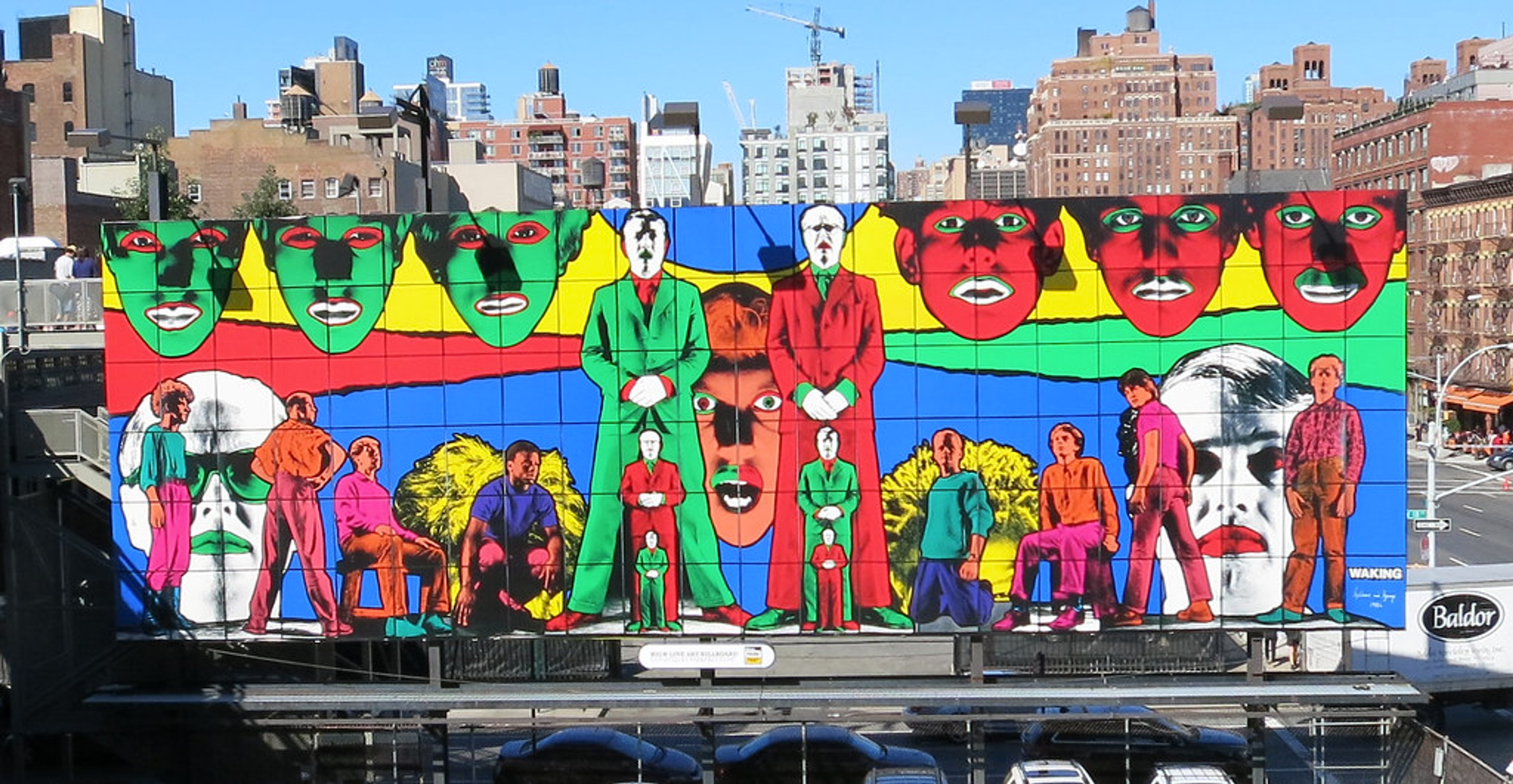 Une fresque monumentale et colorée des artistes Gilbert and George à New York. Elle présente plusieurs représentations des visages des artistes, déclinées en différentes tailles et couleurs.