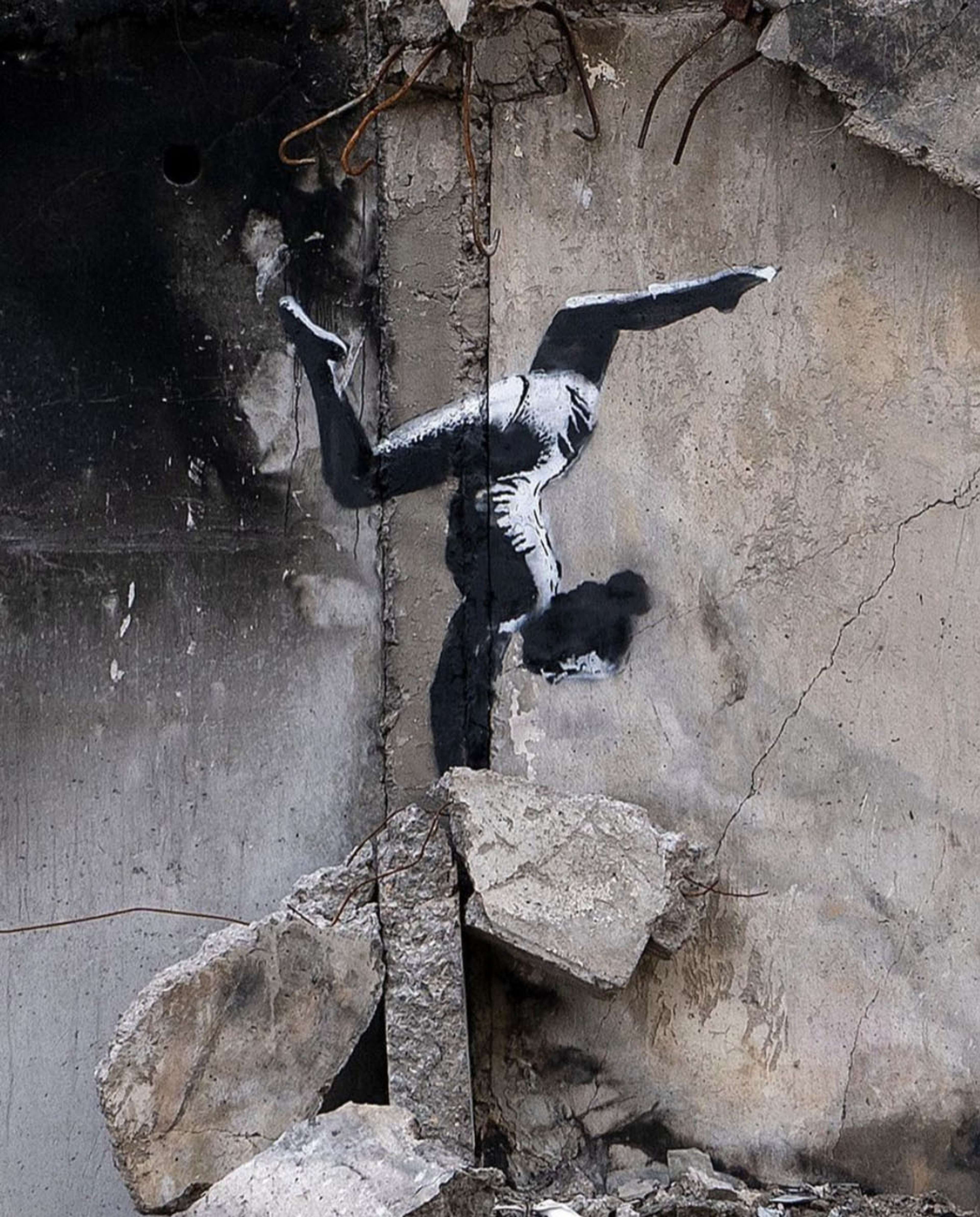 Une fresque murale de Banksy en Ukraine représentant une jeune fille faisant de la gymnastique au milieu des décombres.