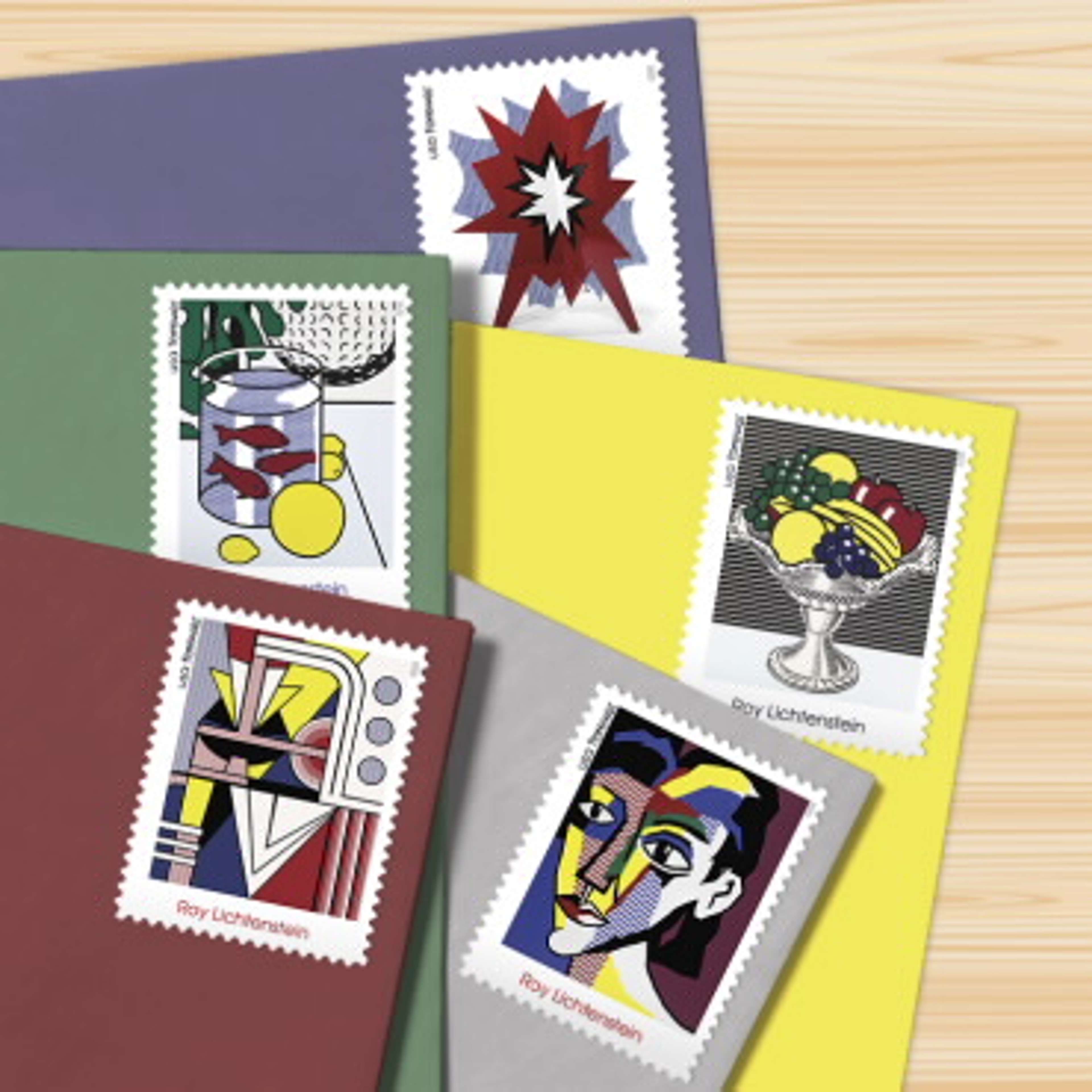 Une photographie montrant cinq des timbres-poste américains de Roy Lichtenstein, reproduisant des œuvres de Lichtenstein