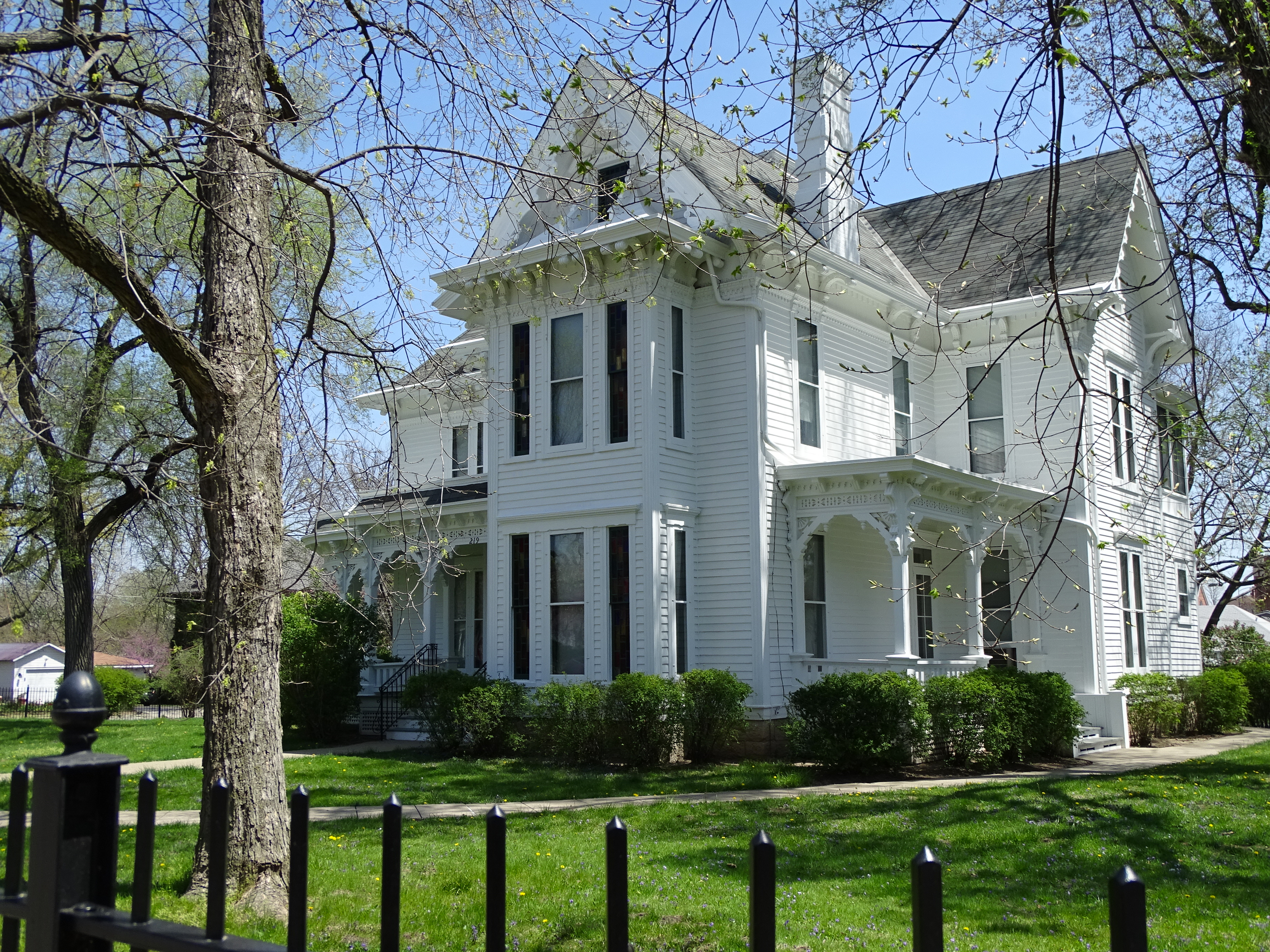 Une image de la bibliothèque présidentielle Harry S. Truman. Une maison blanche de style colonial américain, avec une pelouse d'un vert éclatant.