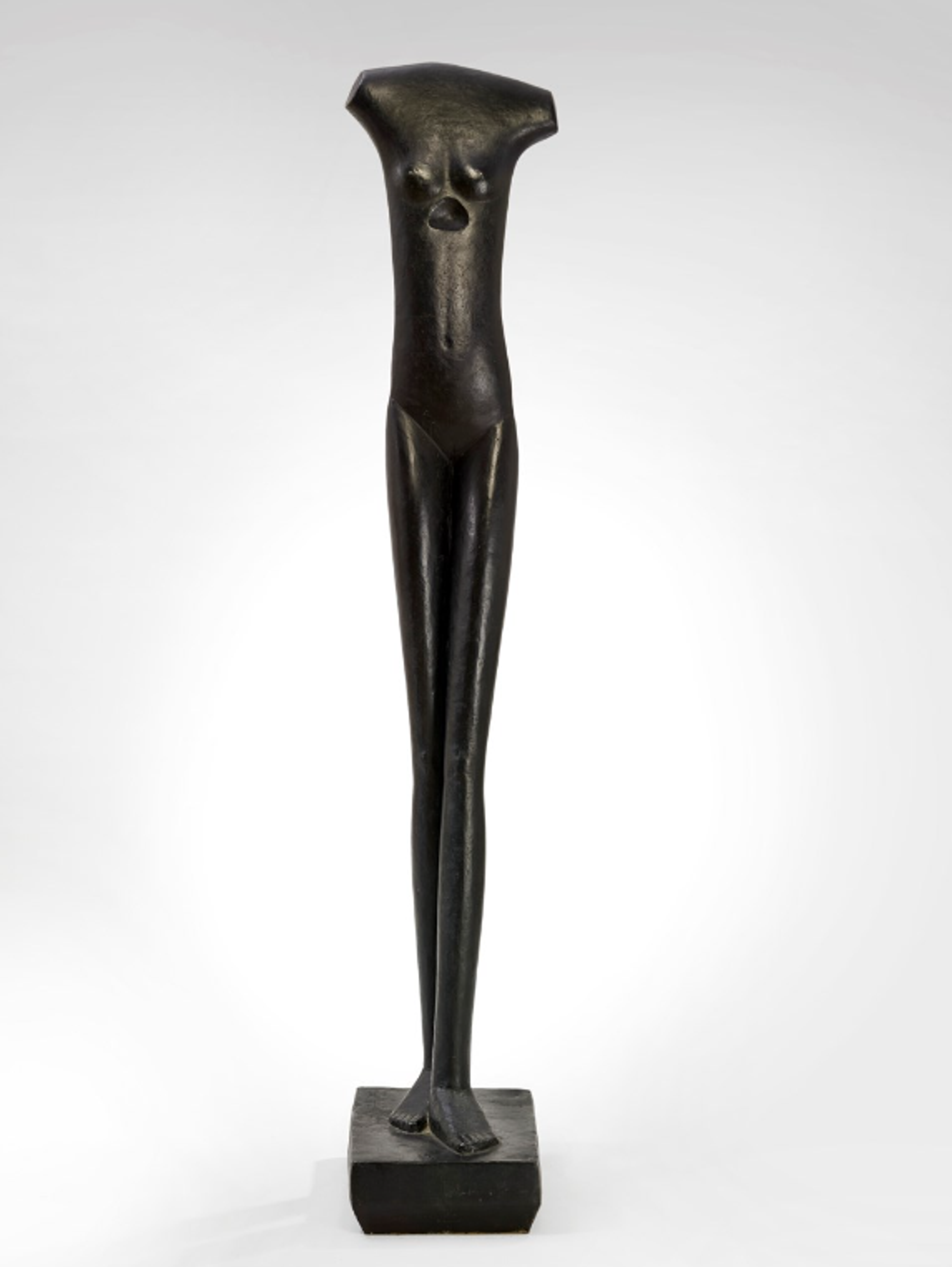 Extremely slender bronze figure with elongated proportions standing on a small rectangular base. The female figure has a smooth, polished surface with minimal detail, creating a stark vertical presence with attenuated limbs and torso. A curved triangular indent has been cut into her ribs.