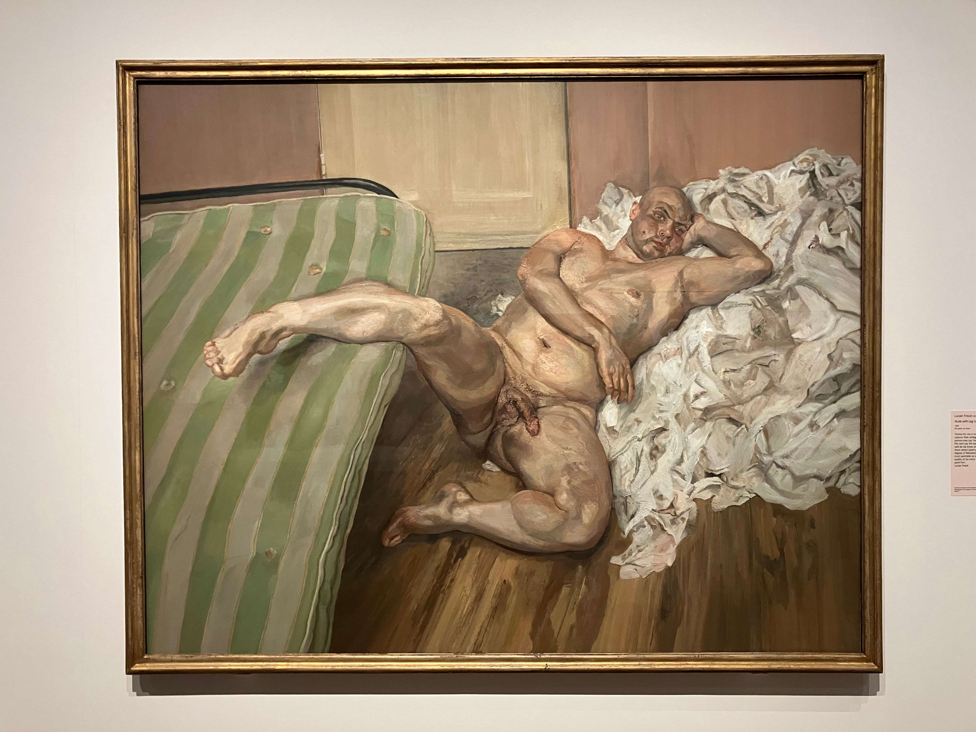 Tableau d'un homme nu allongé sur le sol, une jambe relevée et reposant sur un lit