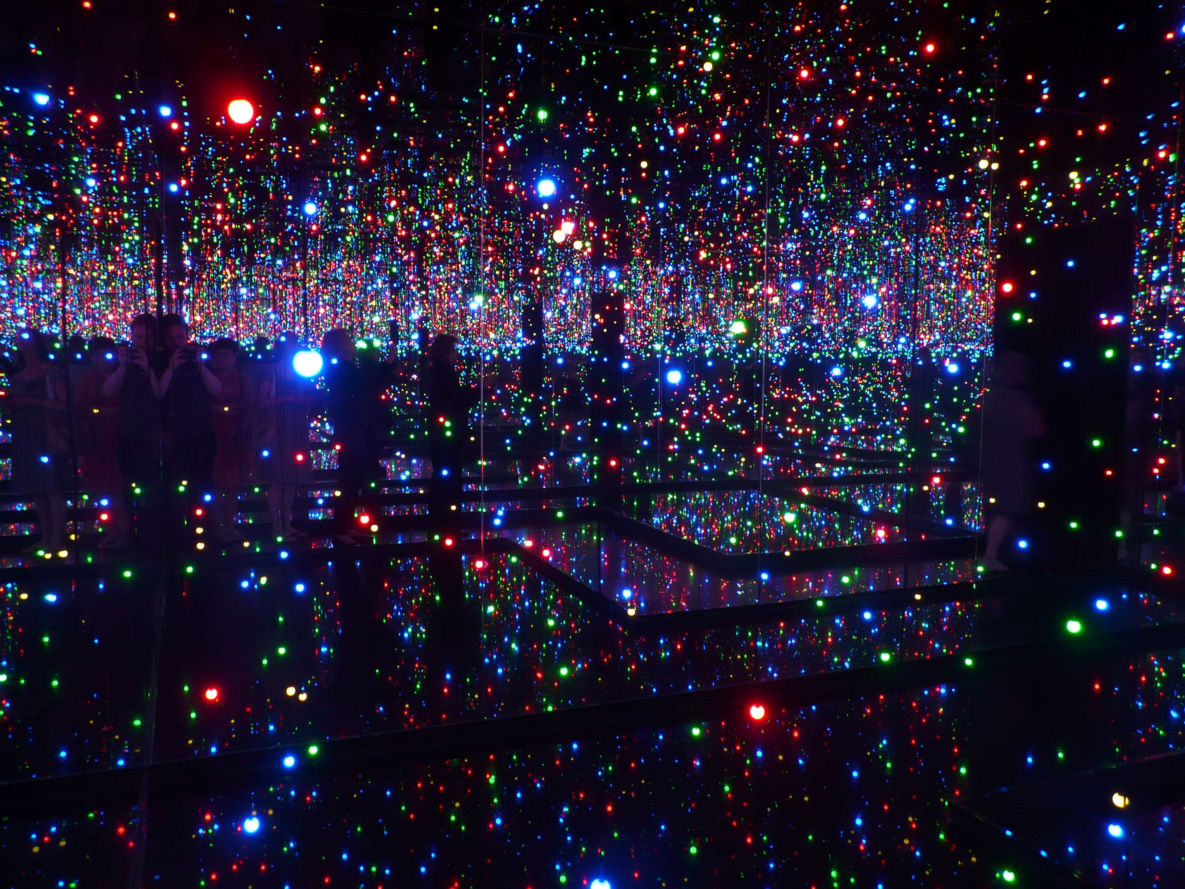 Image d'une pièce sombre remplie de miroirs et de lumières réfléchies