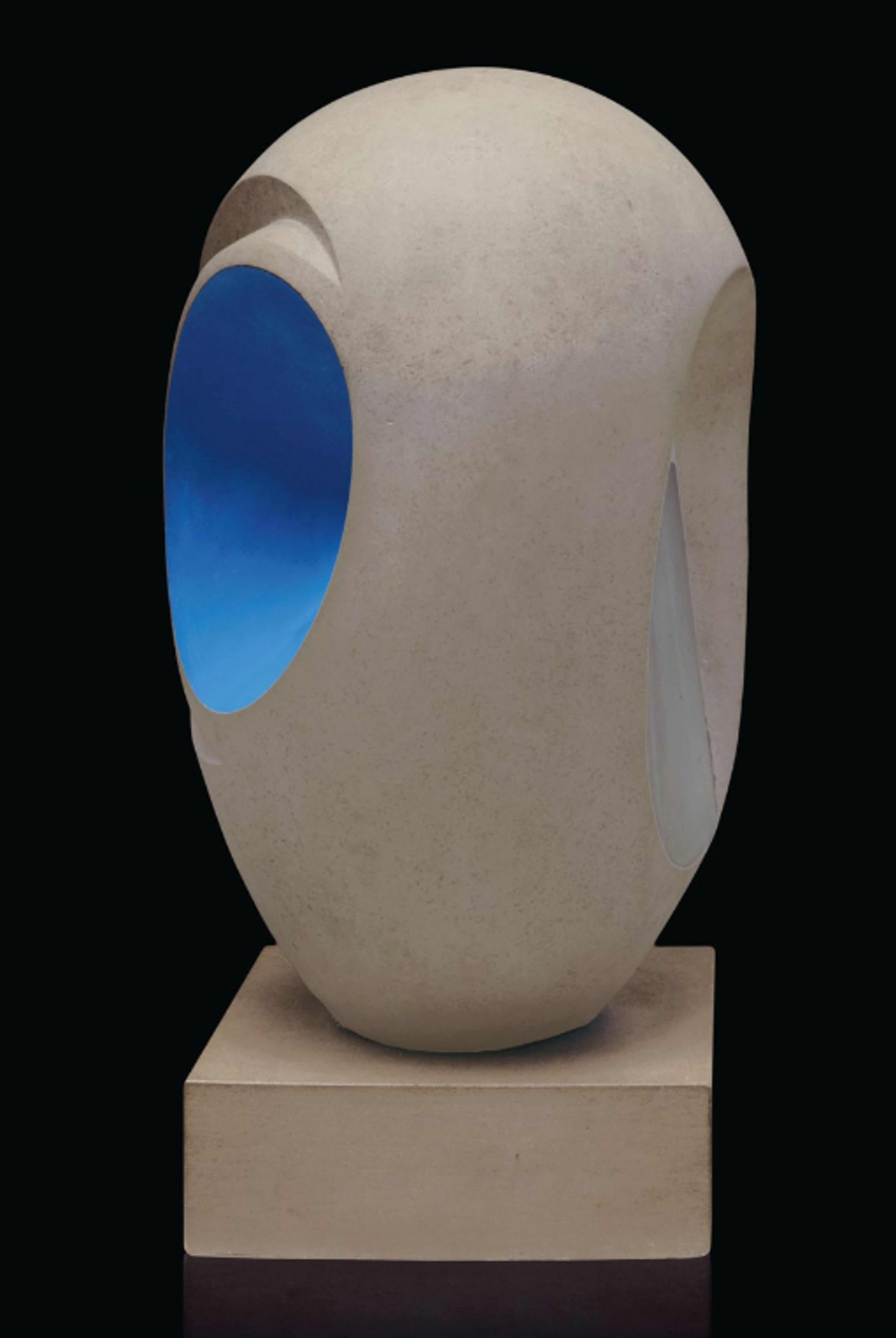 A sculpture with a curved, seed-like outer shape and a bright turquoise interior, visible through rounded openings on either side. Additional grooves outline the opening on one side. 