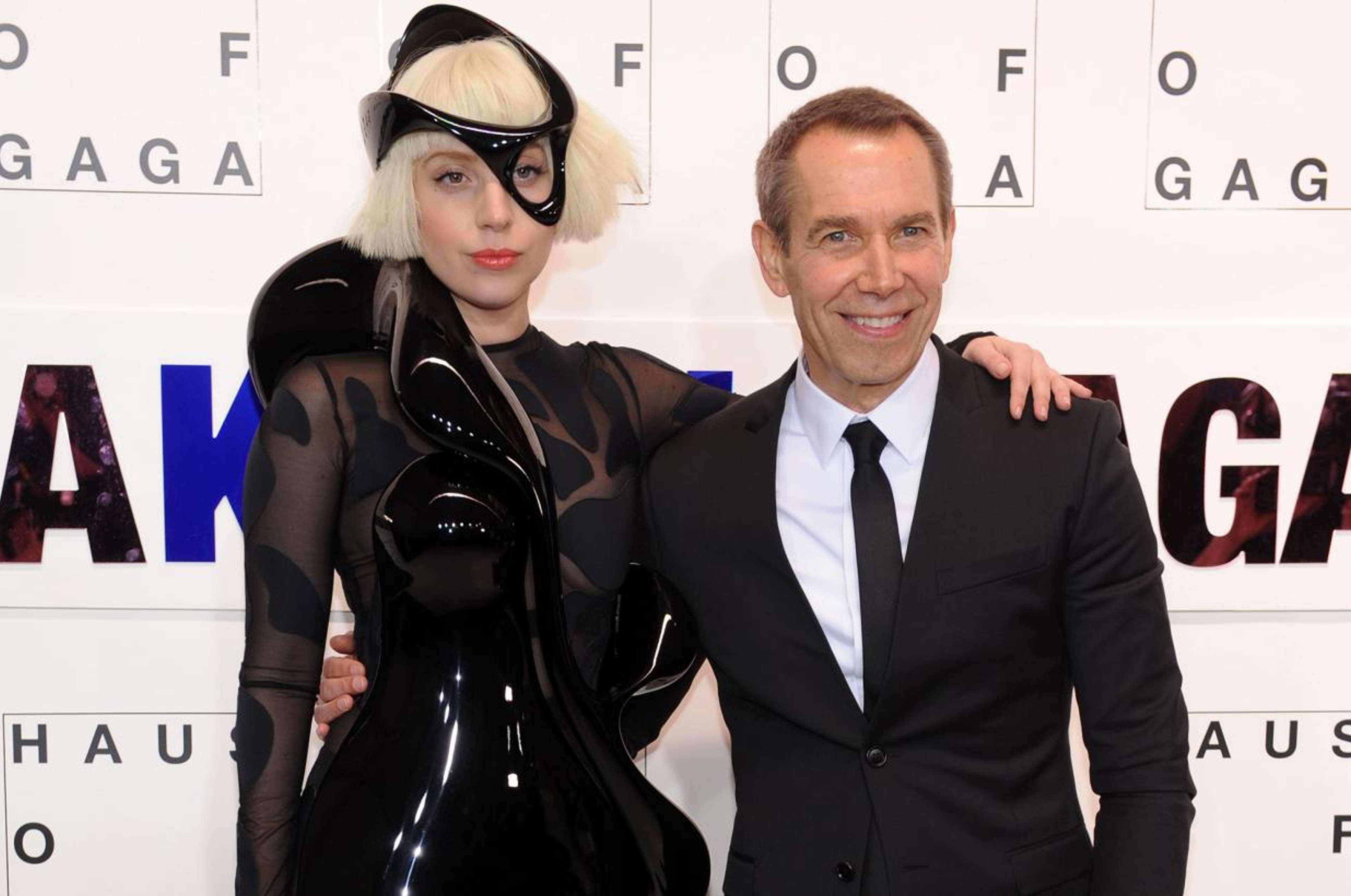 Une photographie de l'artiste Jeff Koons aux côtés de la musicienne Lady Gaga. Ils s'enlacent devant un fond blanc.