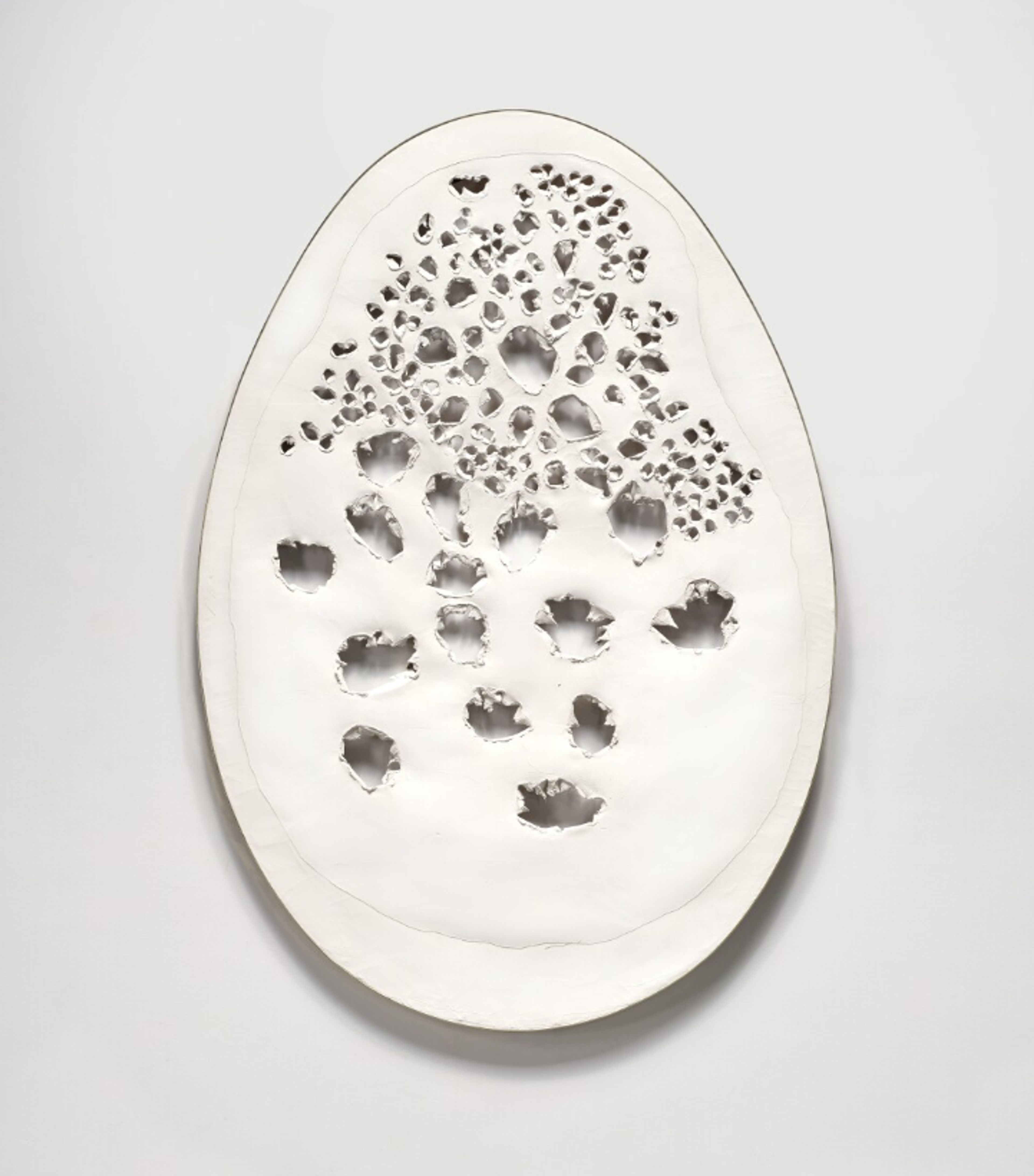 A black egg-shaped canvas, decorated mainly with irregular large perforations. Smaller perforations loop around some of the large holes.