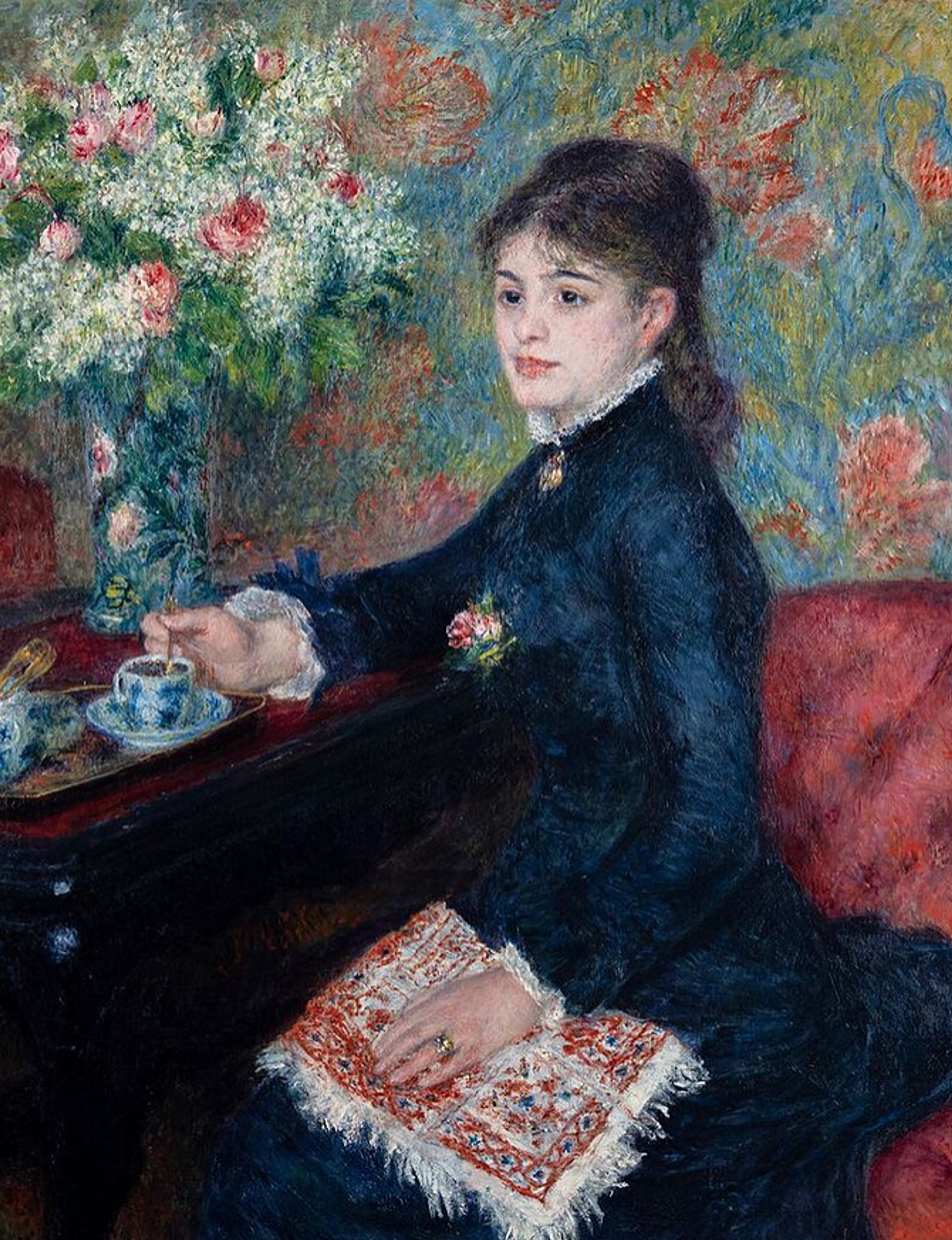 A young woman in a high-necked black dress sits at a table with a cup of hot chocolate. A vase of white flowers sits on the table beside her. A book with a red cover or cross-stitch pattern rests on her lap. The scene is painted with bright, impressionistic colours.